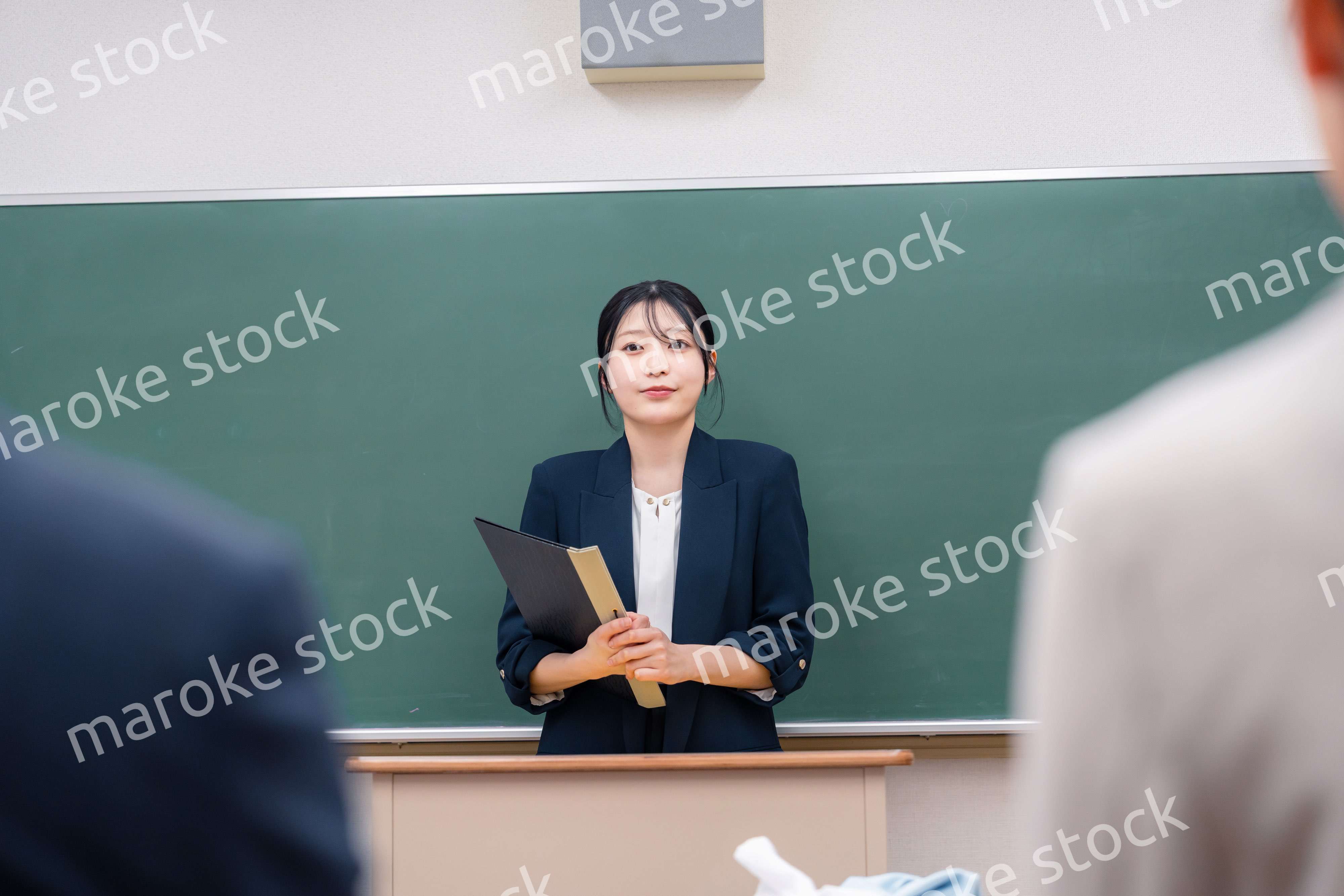 学校で教壇に立って授業をする若い女性教師