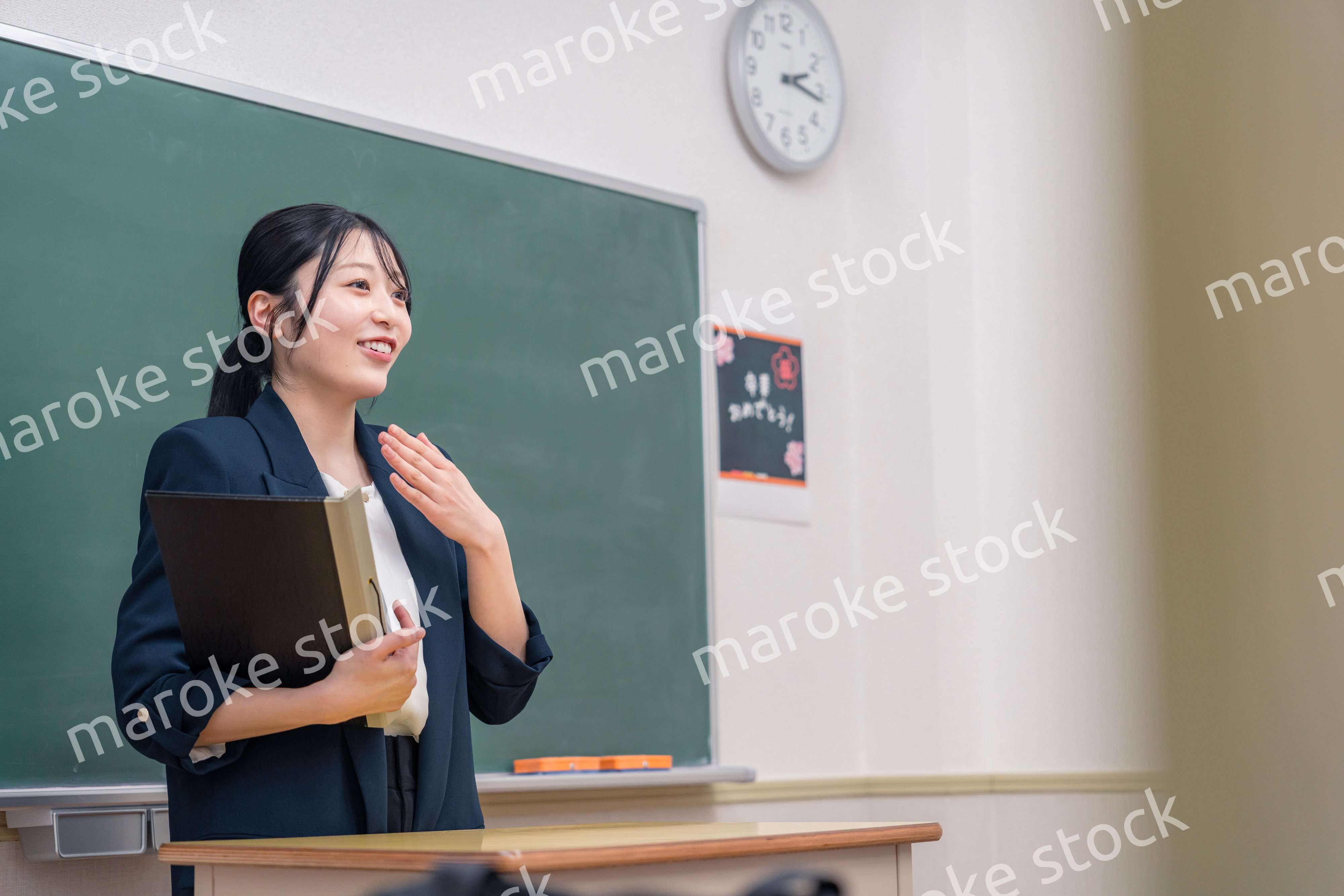 学校で教壇に立って授業をする若い女性教師