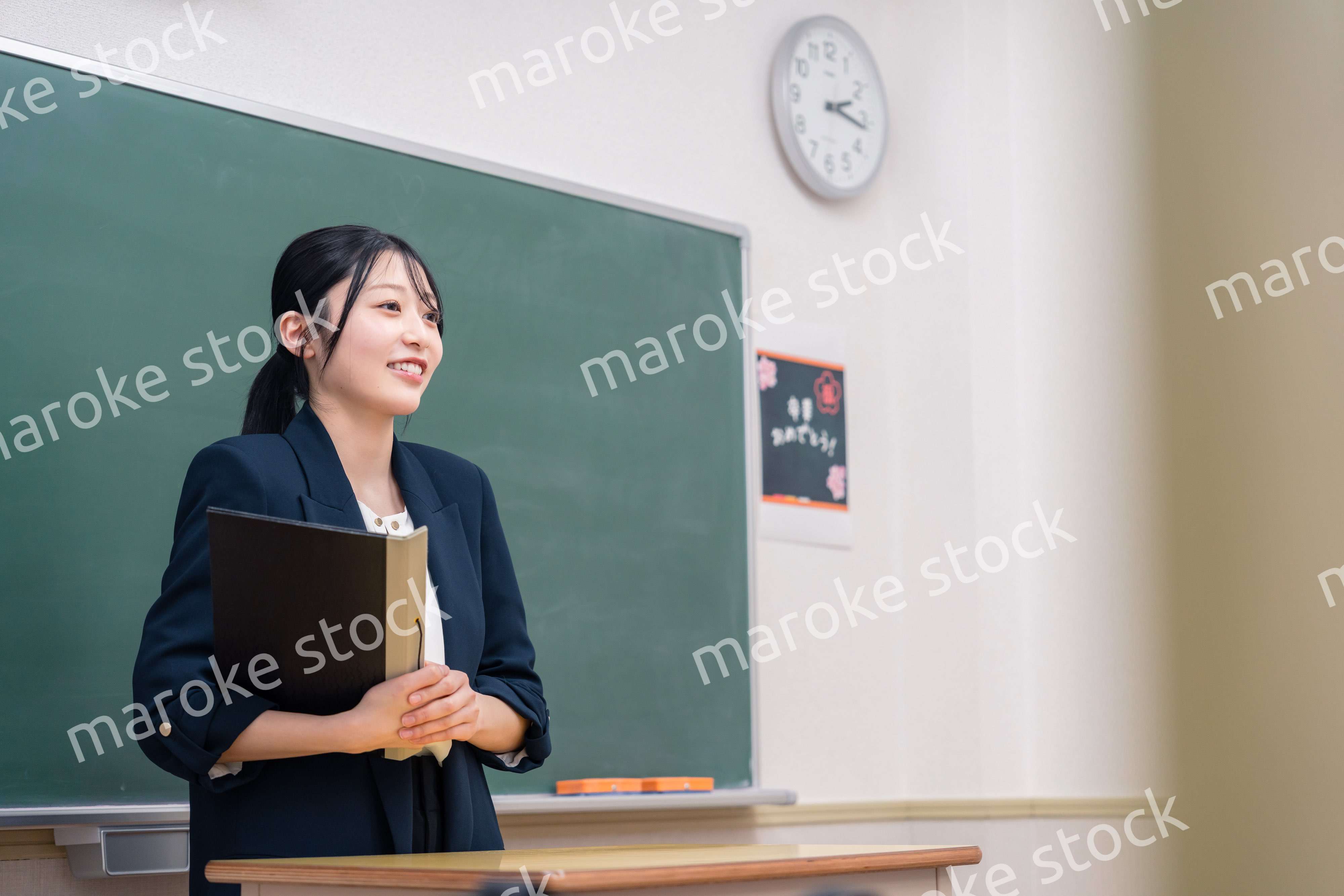 学校で教壇に立って授業をする若い女性教師