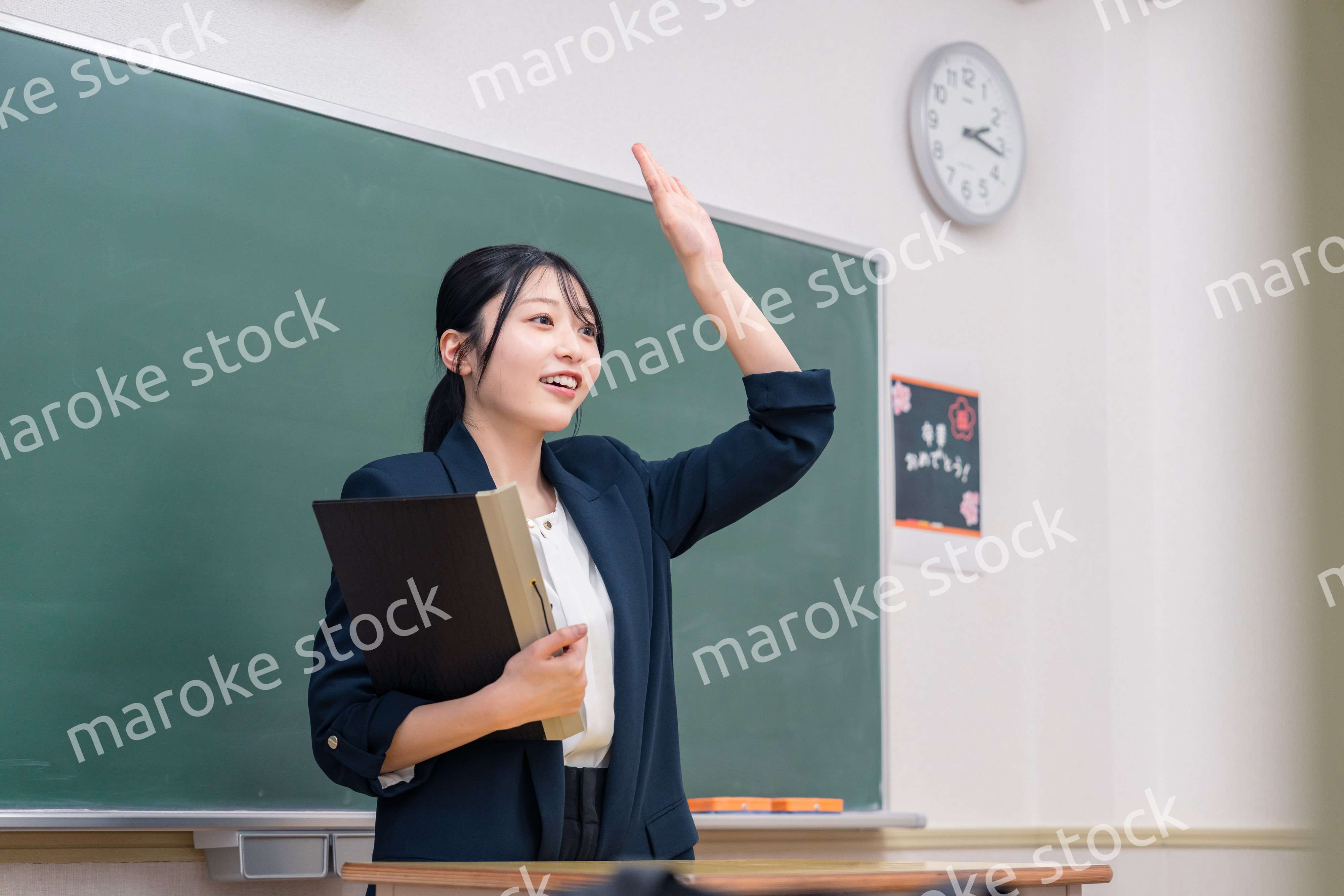 学校で教壇に立って授業をする若い女性教師