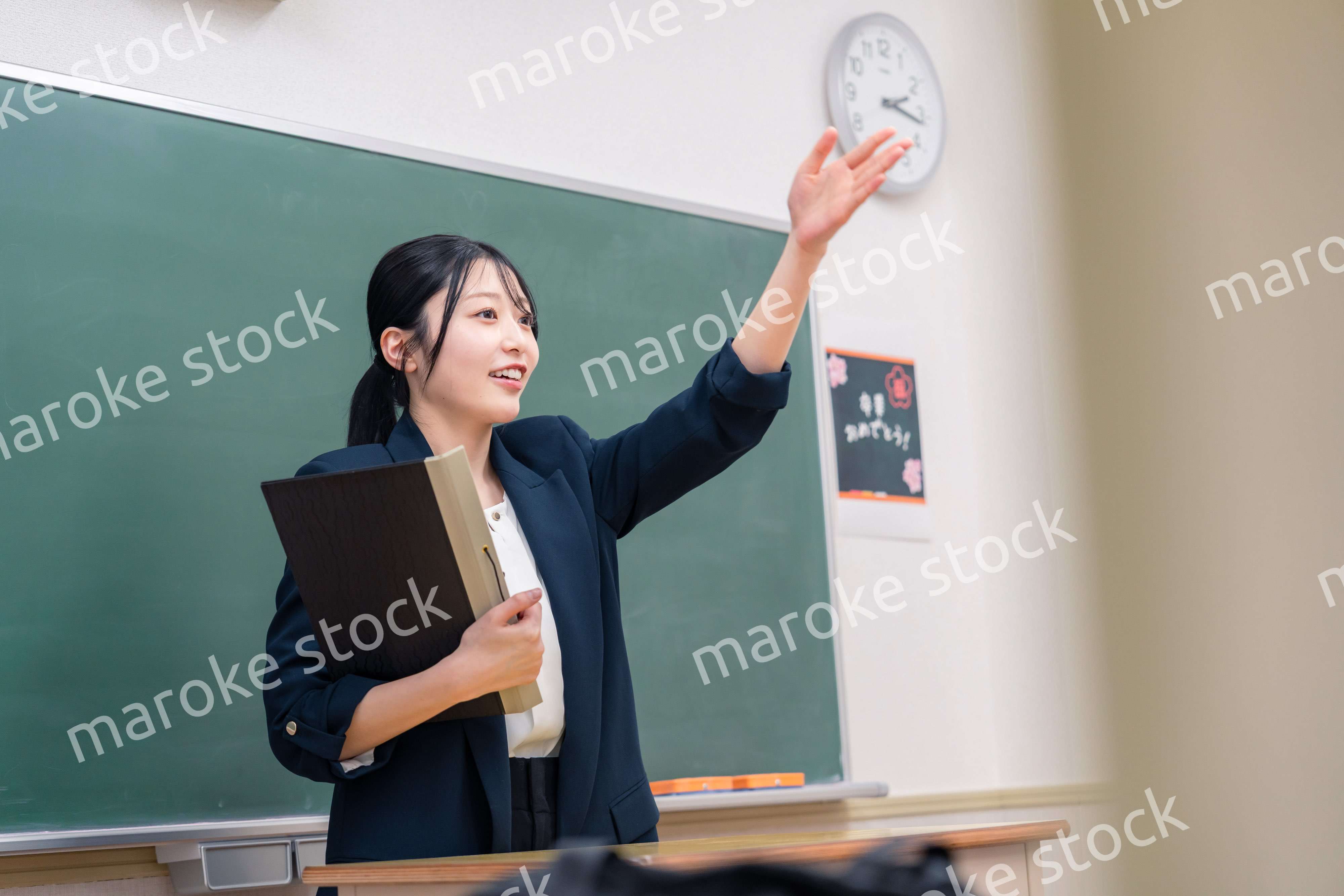学校で教壇に立って授業をする若い女性教師