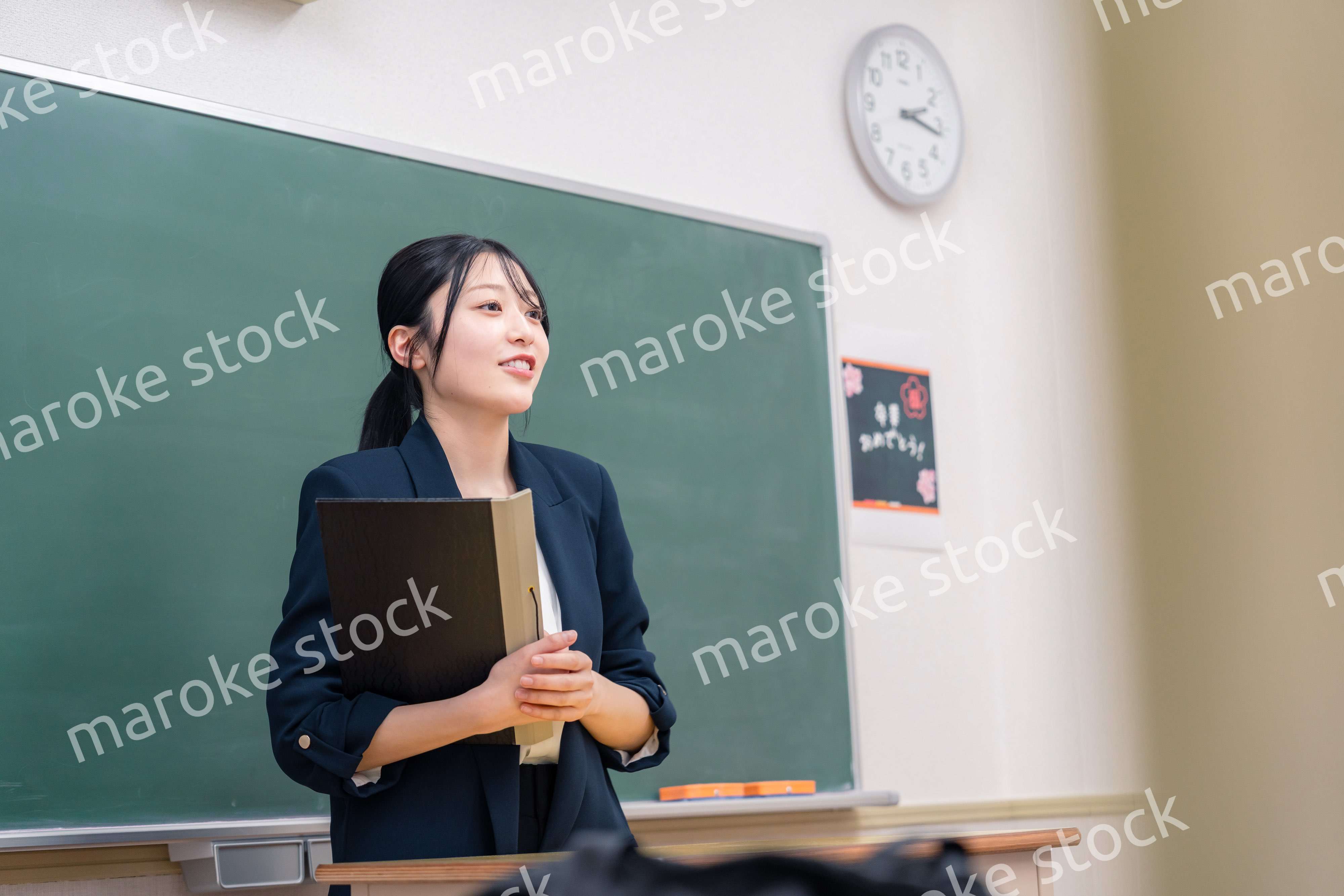 学校で教壇に立って授業をする若い女性教師