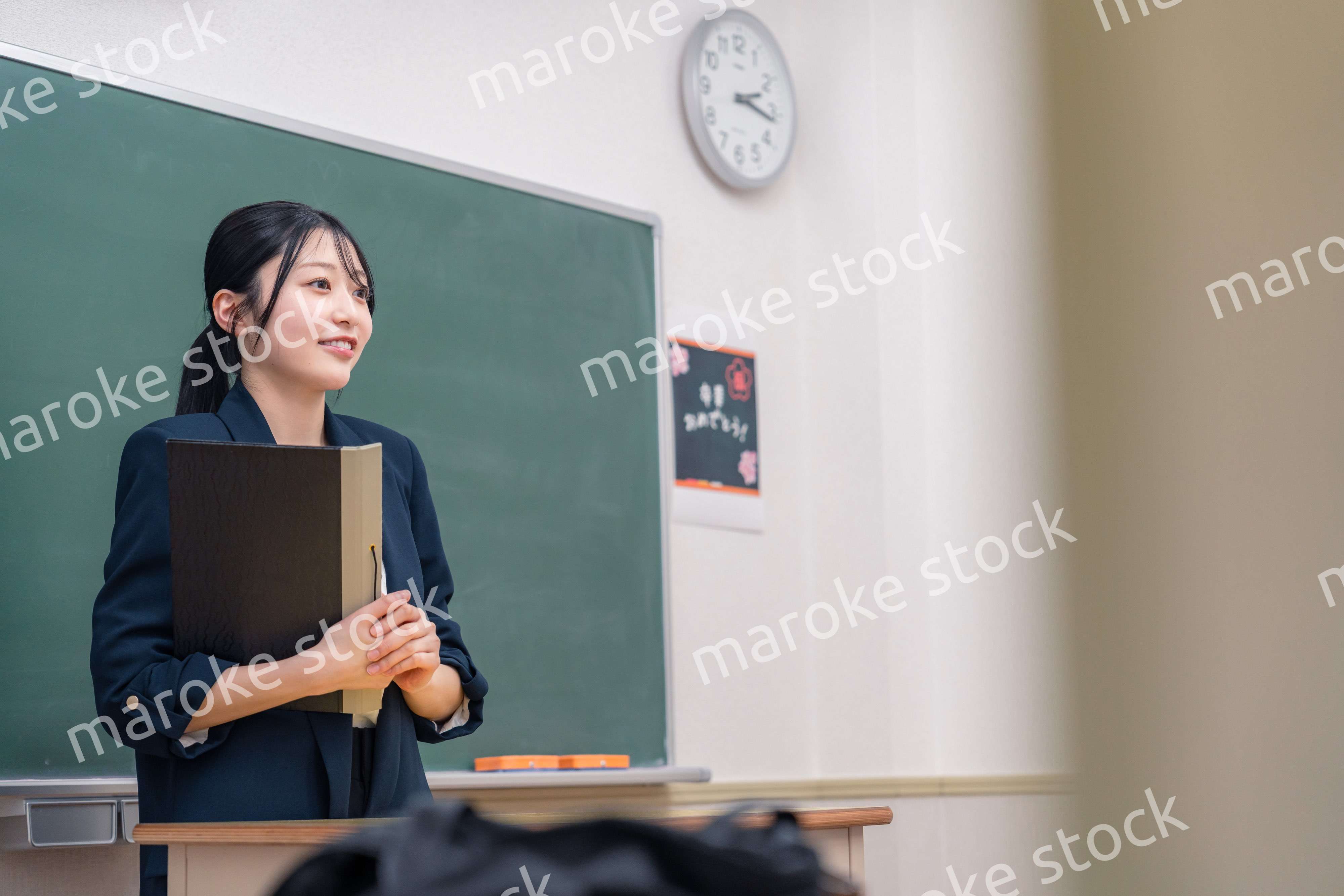 学校で教壇に立って授業をする若い女性教師