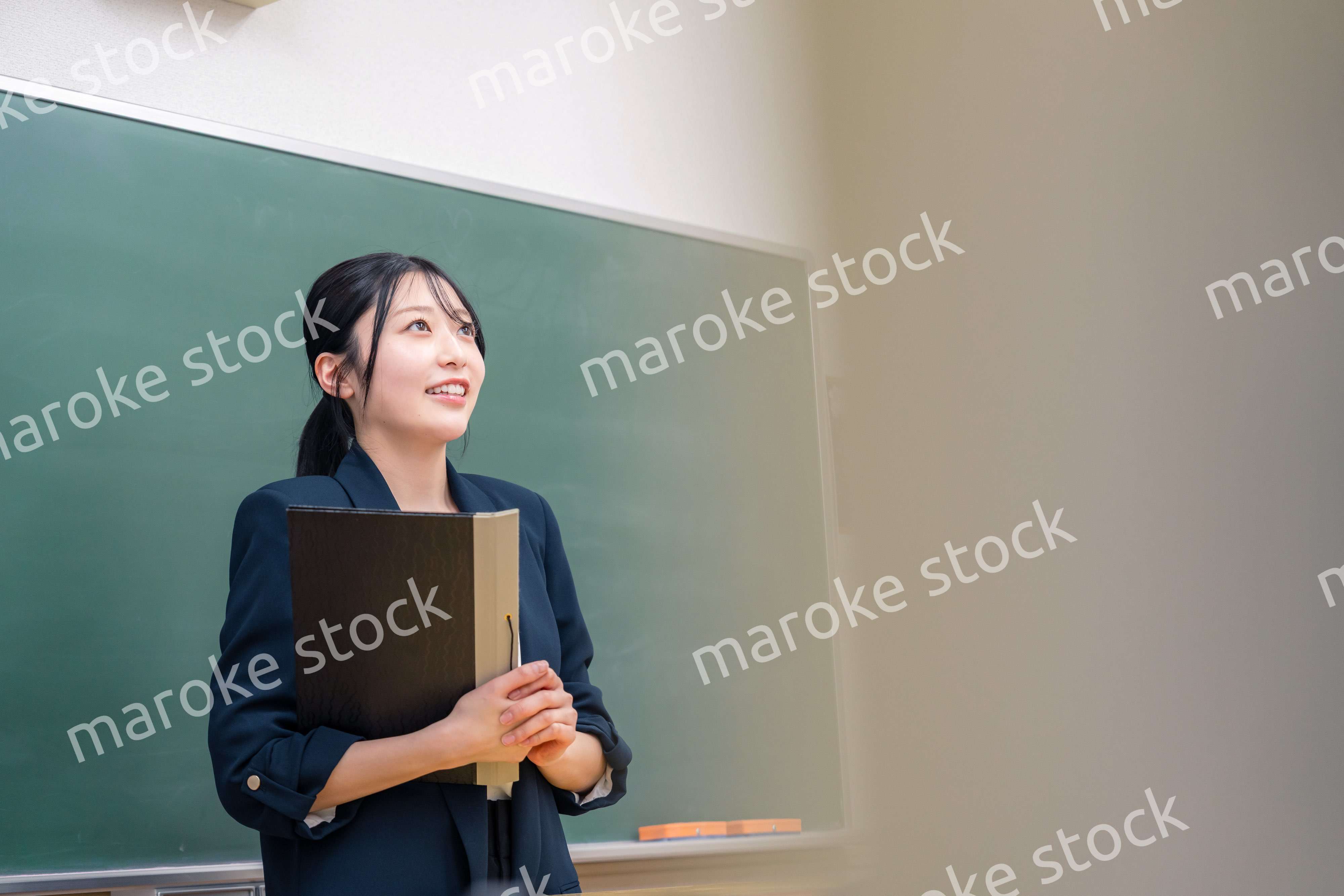 学校で教壇に立って授業をする若い女性教師