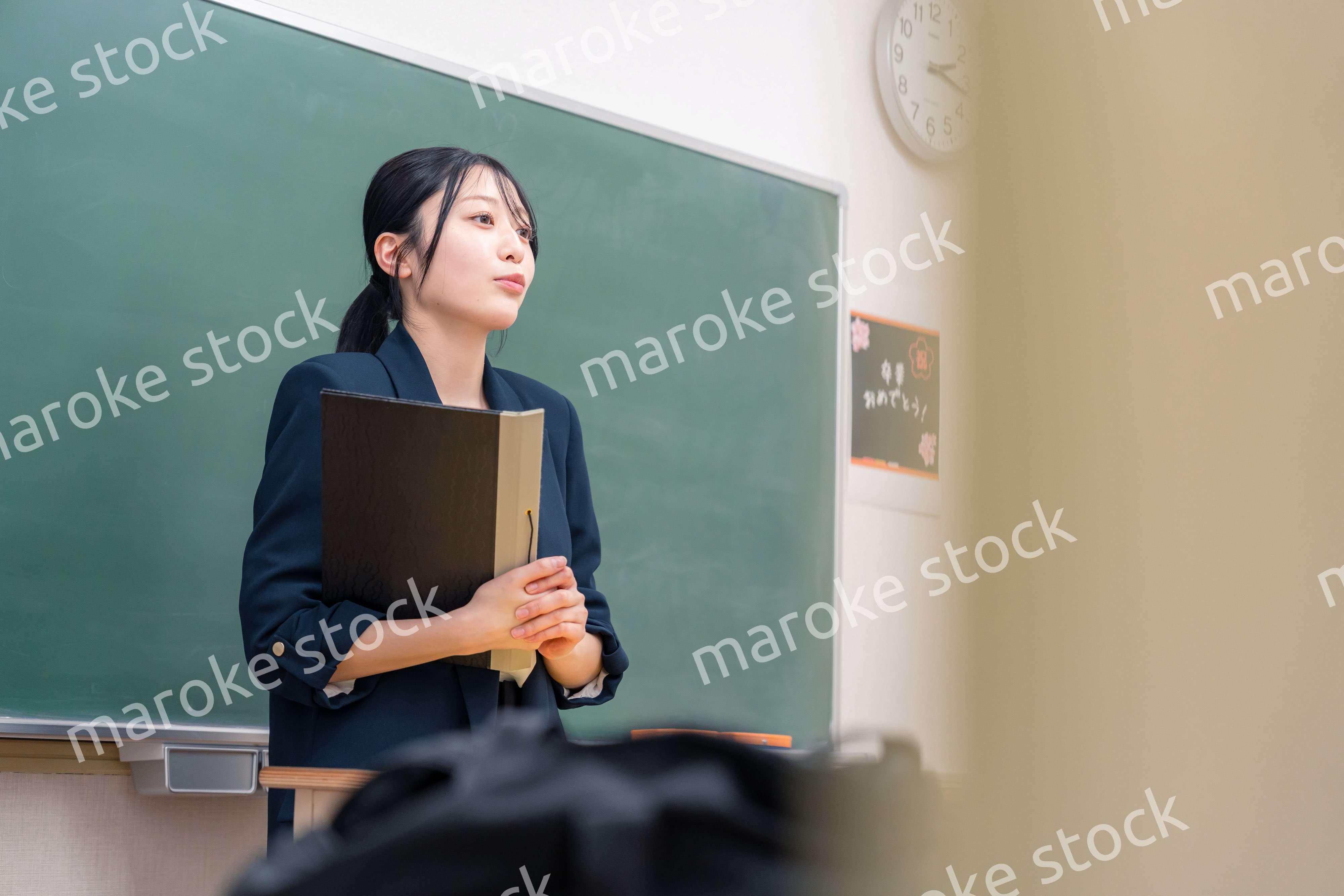 学校で教壇に立って授業をする若い女性教師