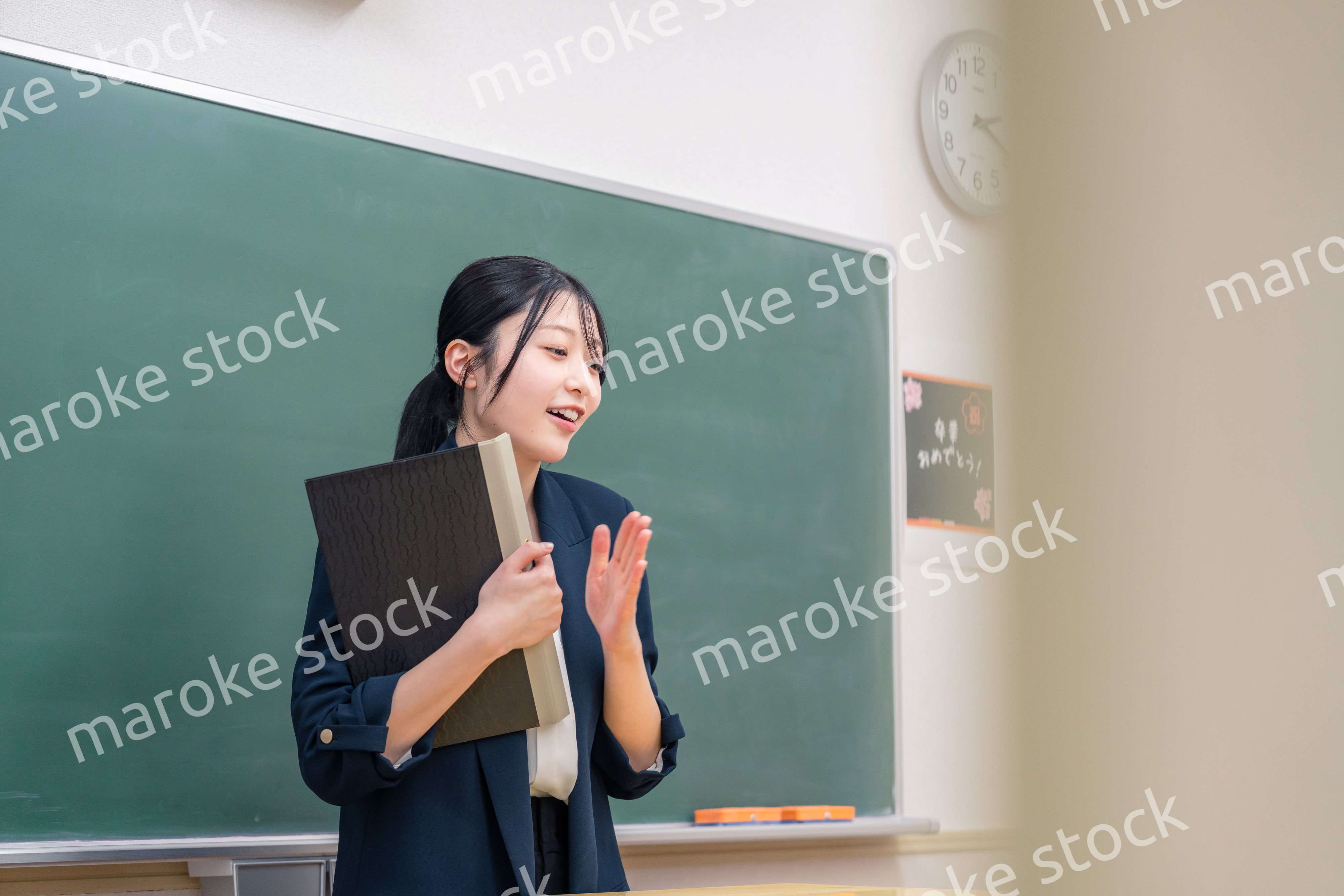 学校で教壇に立って授業をする若い女性教師