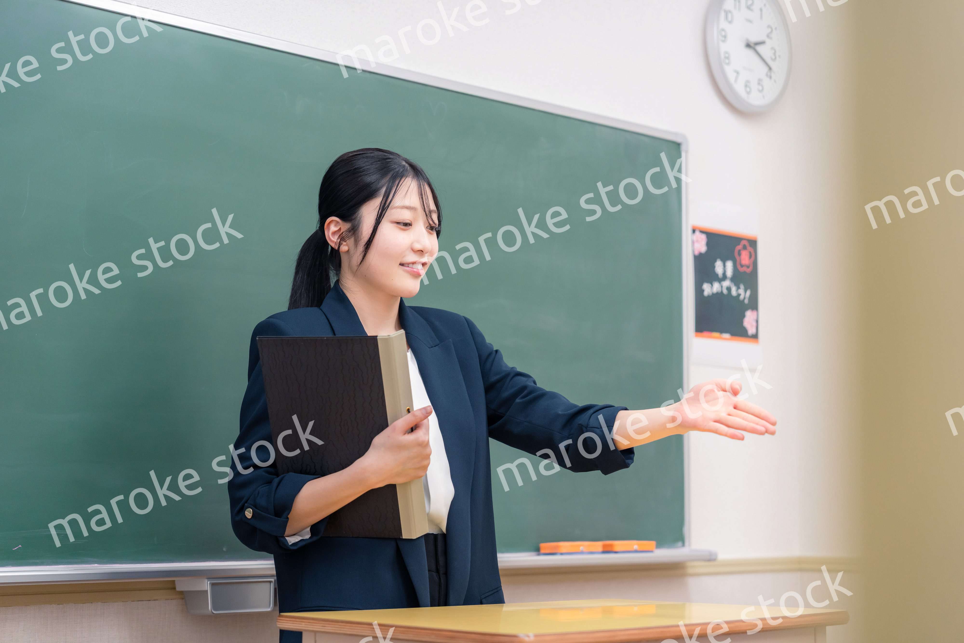 学校で教壇に立って授業をする若い女性教師