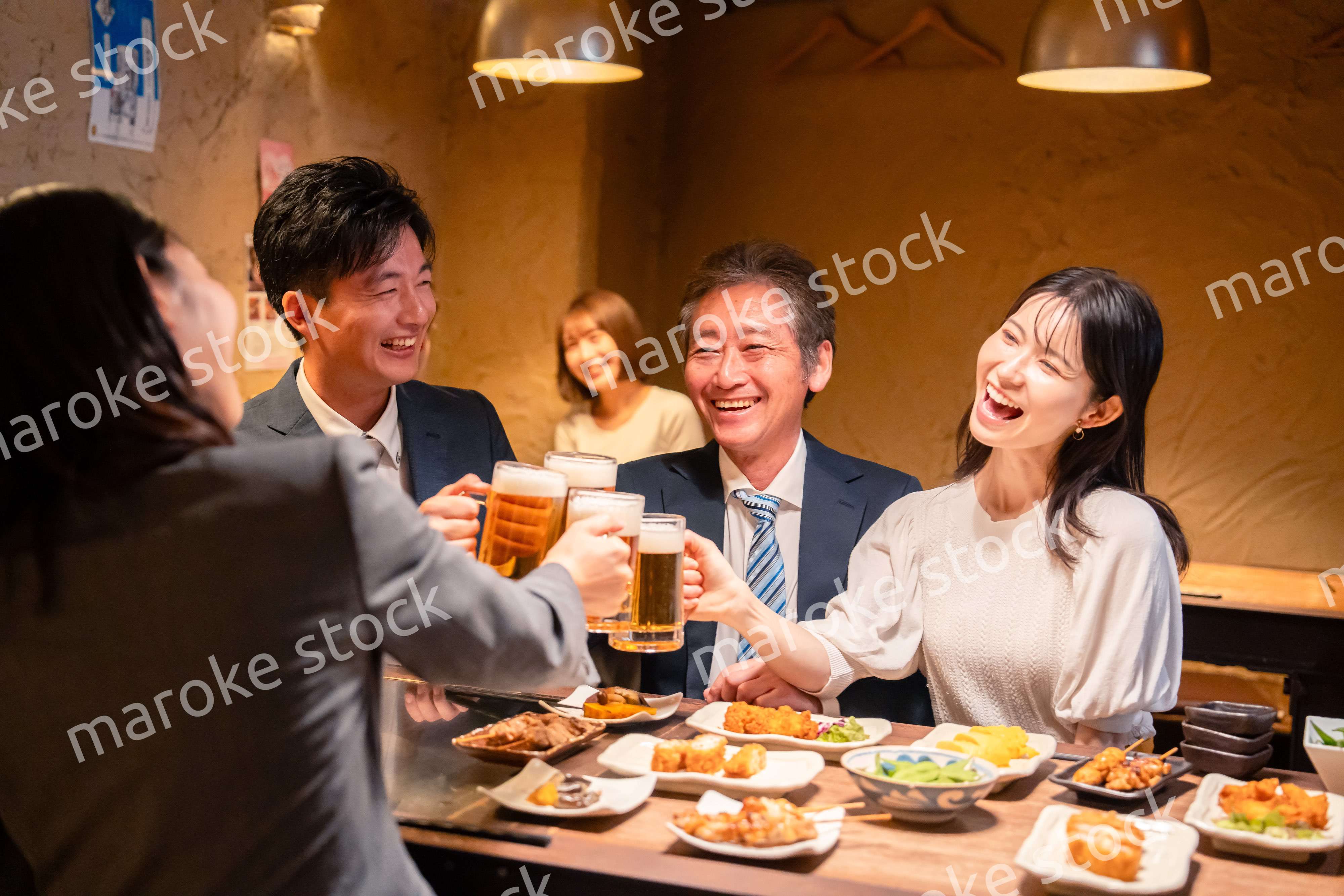 居酒屋で乾杯をする男女のビジネスパーソン