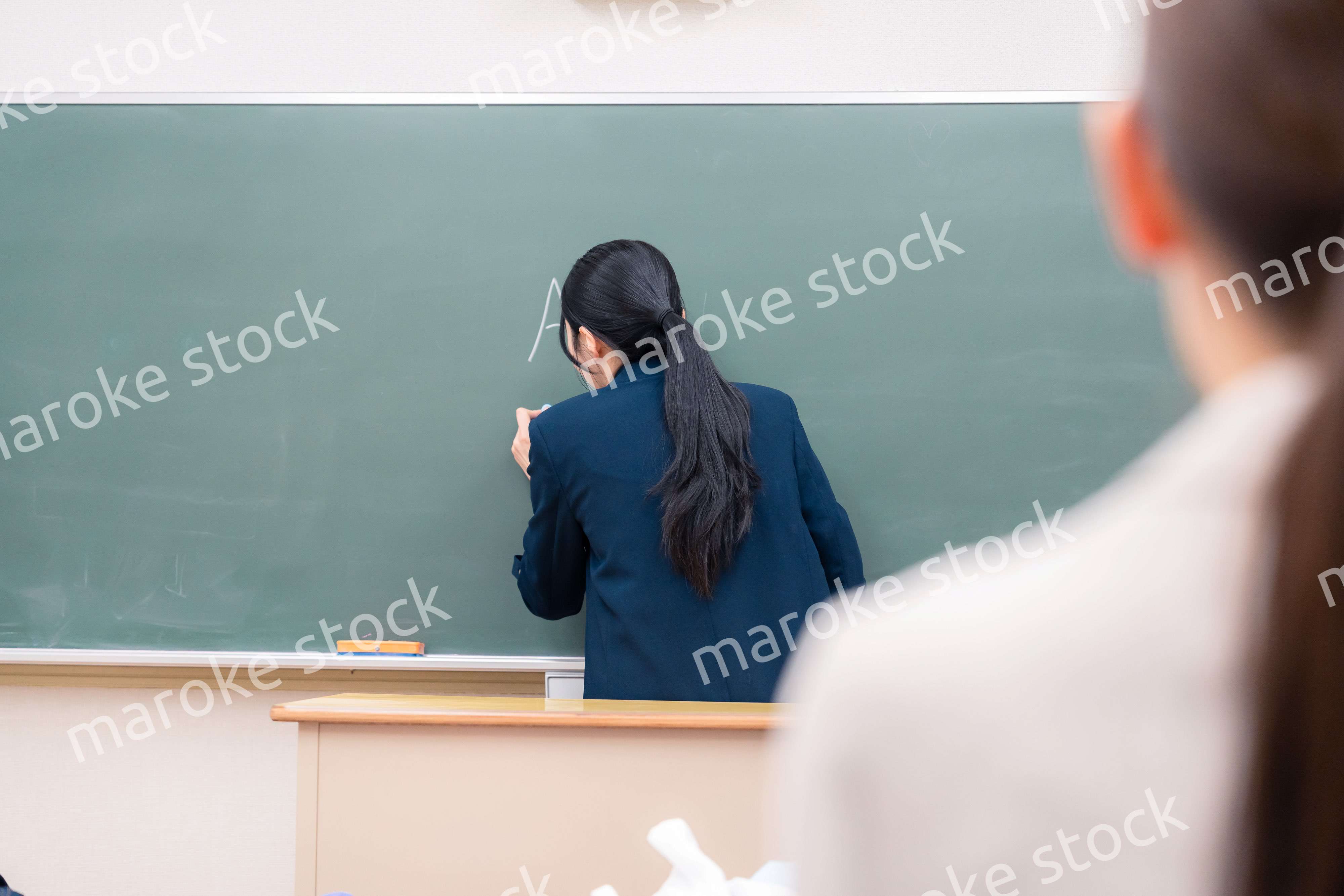 教室で授業をする女性の教師