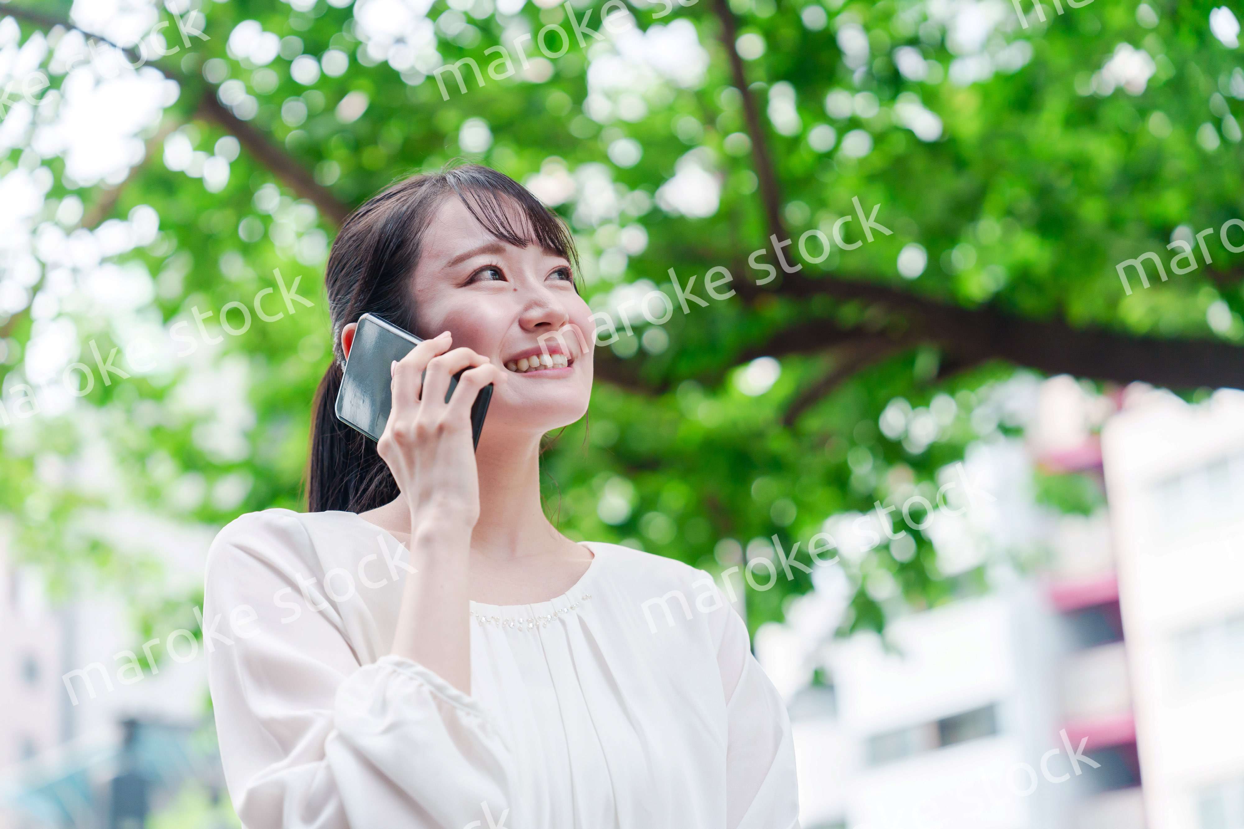 外で通話をする若い女性