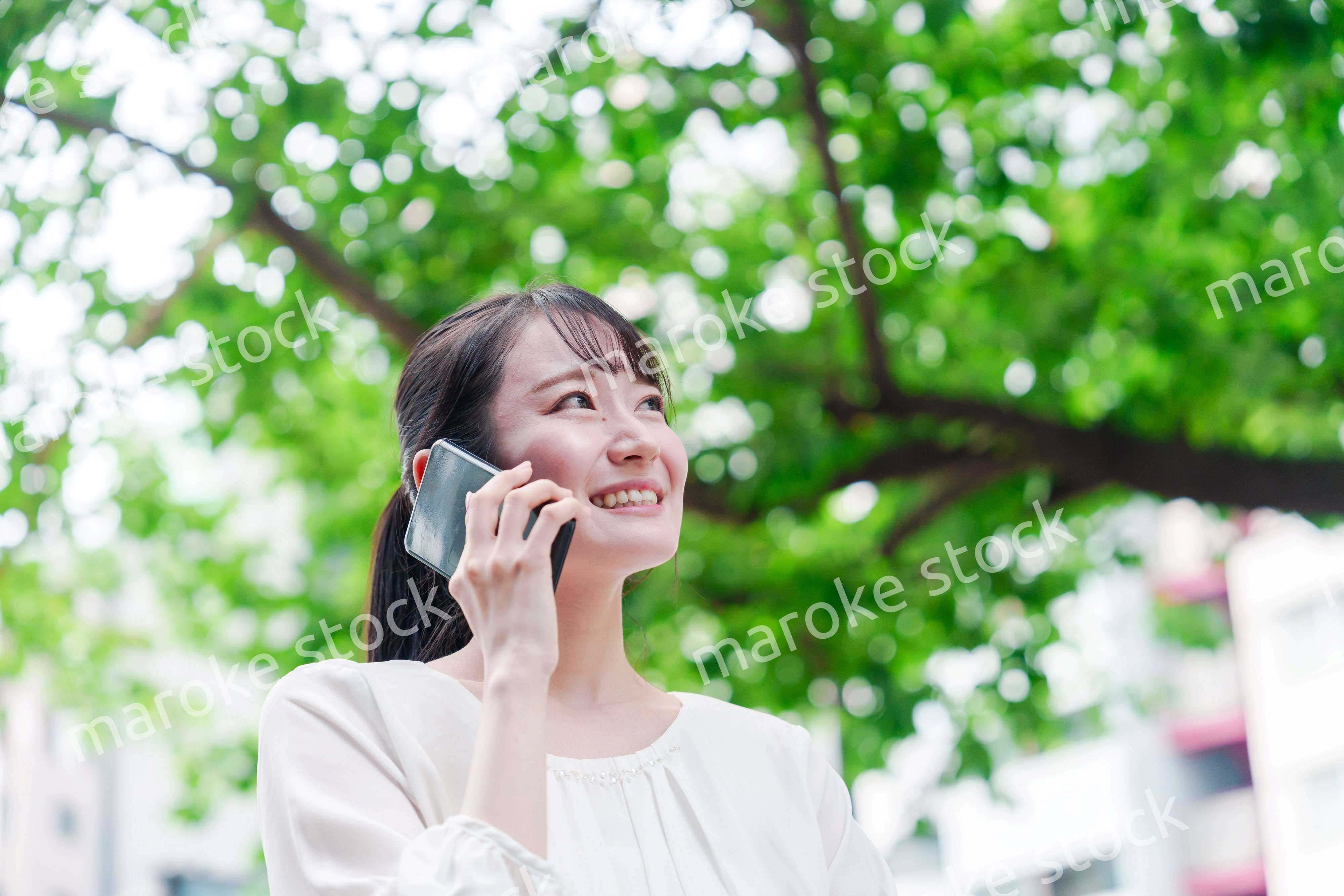 外で通話をする若い女性