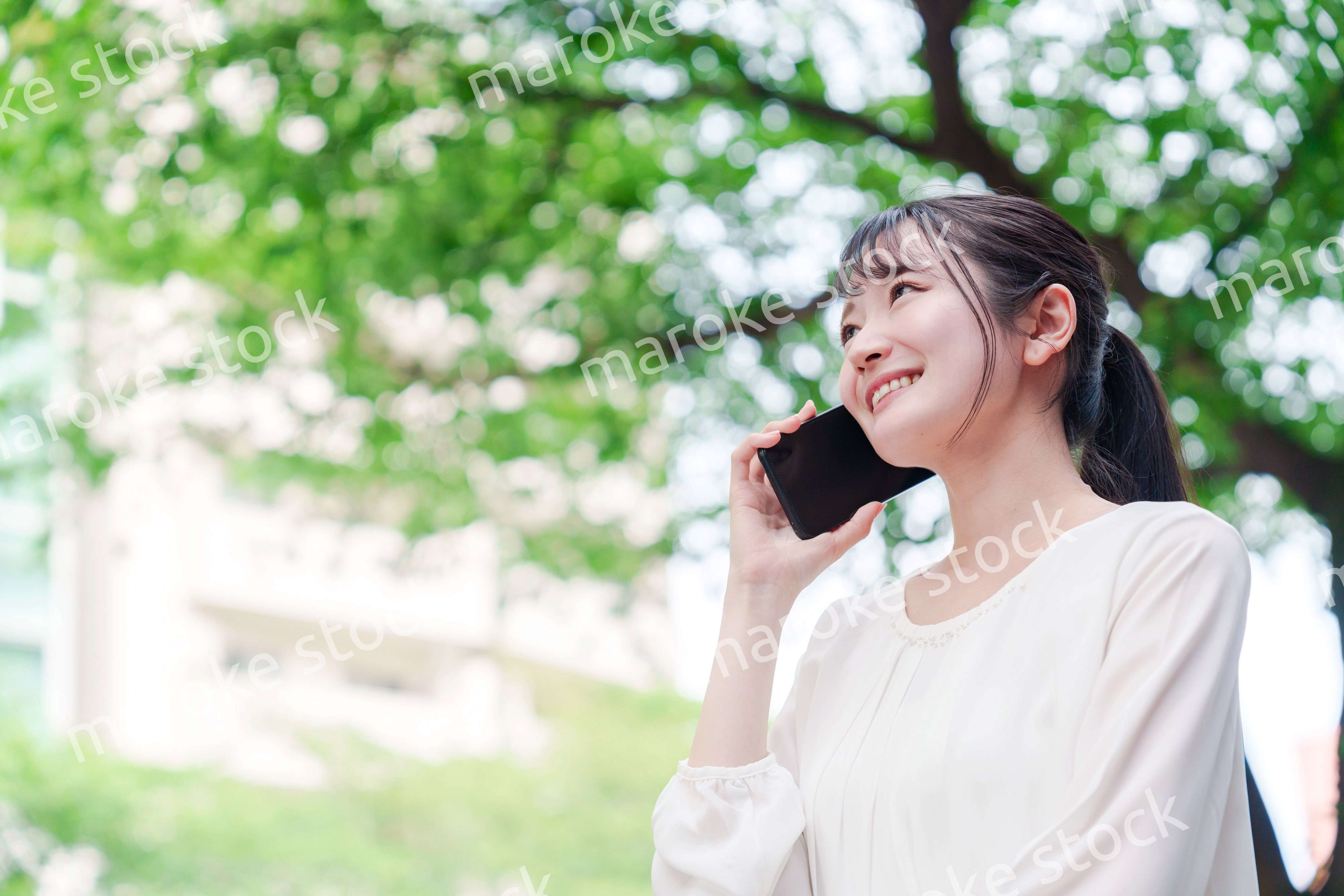 外で通話をする若い女性