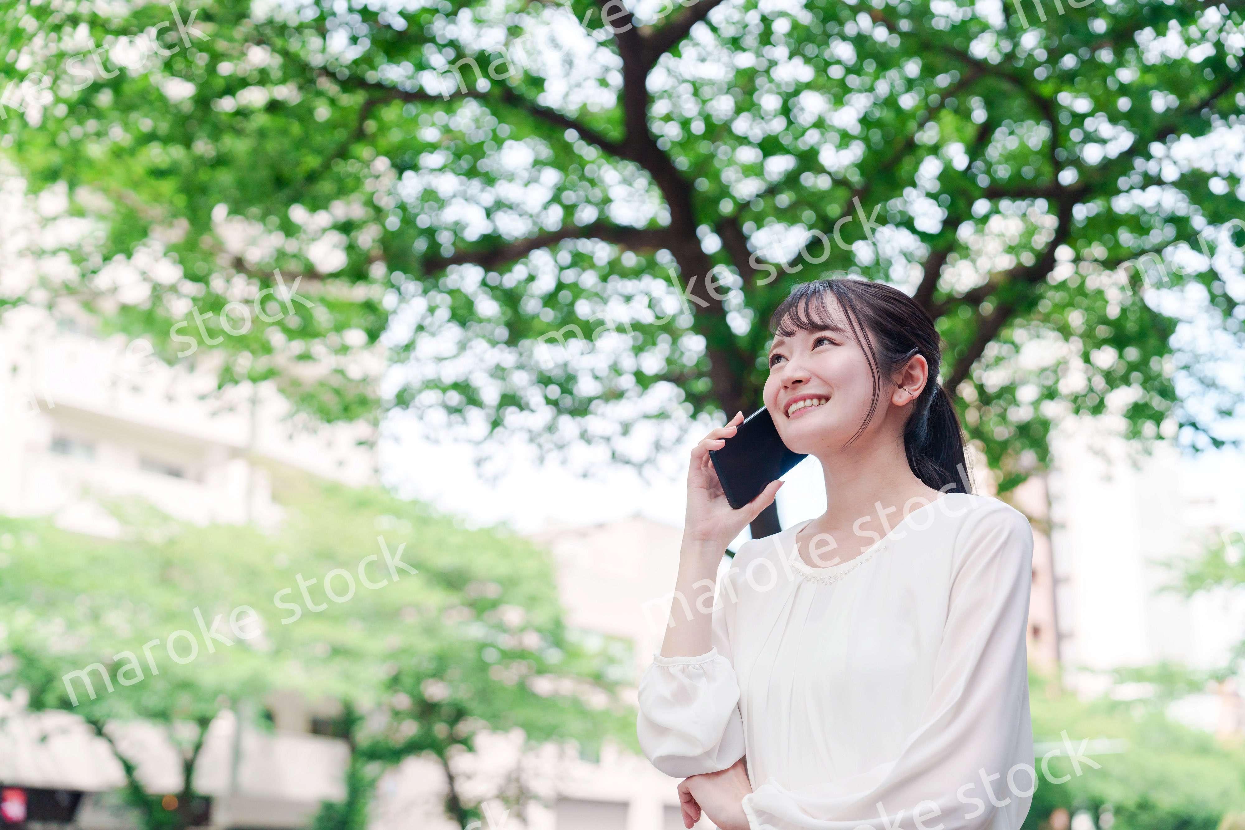 外で通話をする若い女性