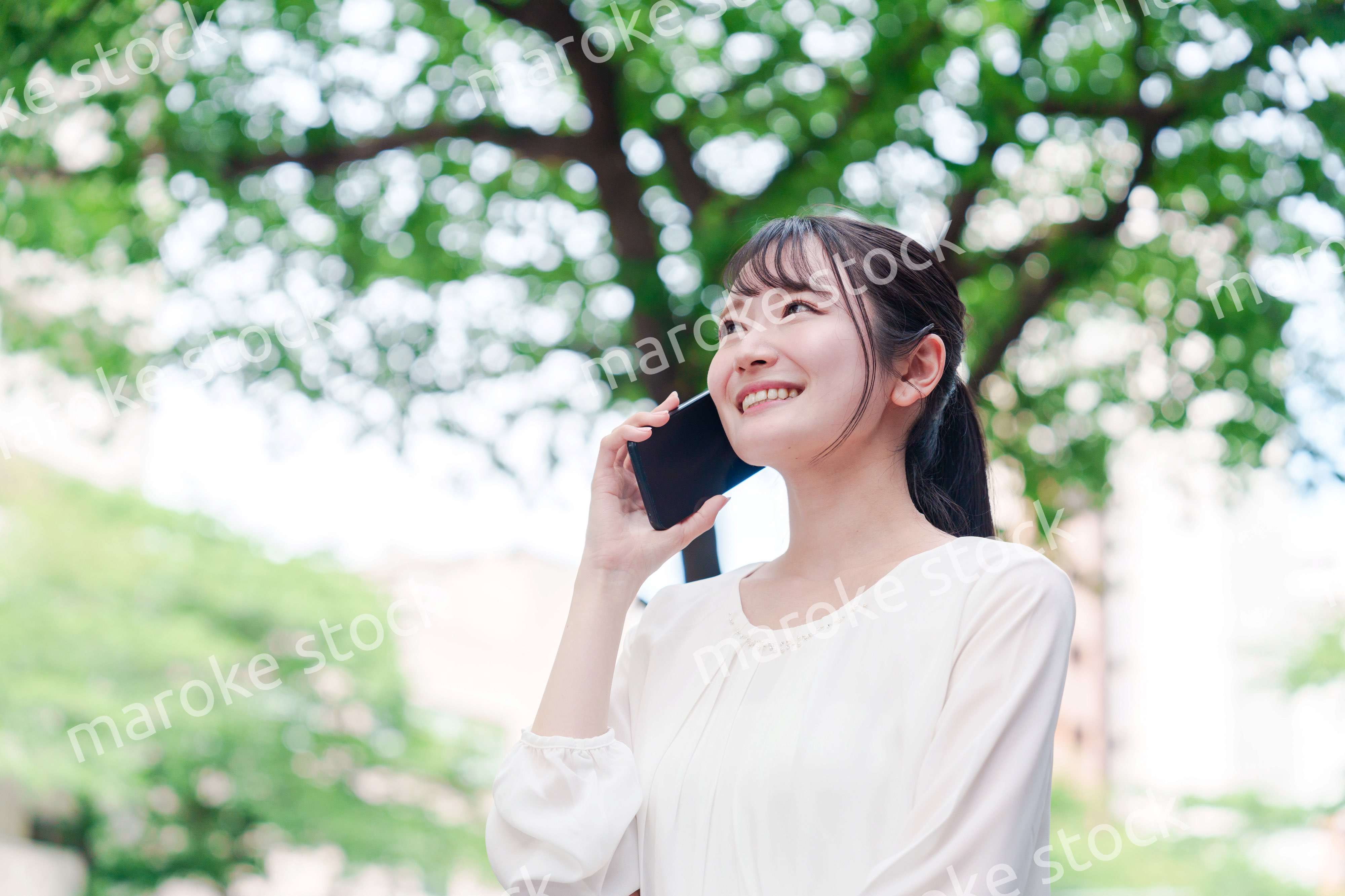 外で通話をする若い女性