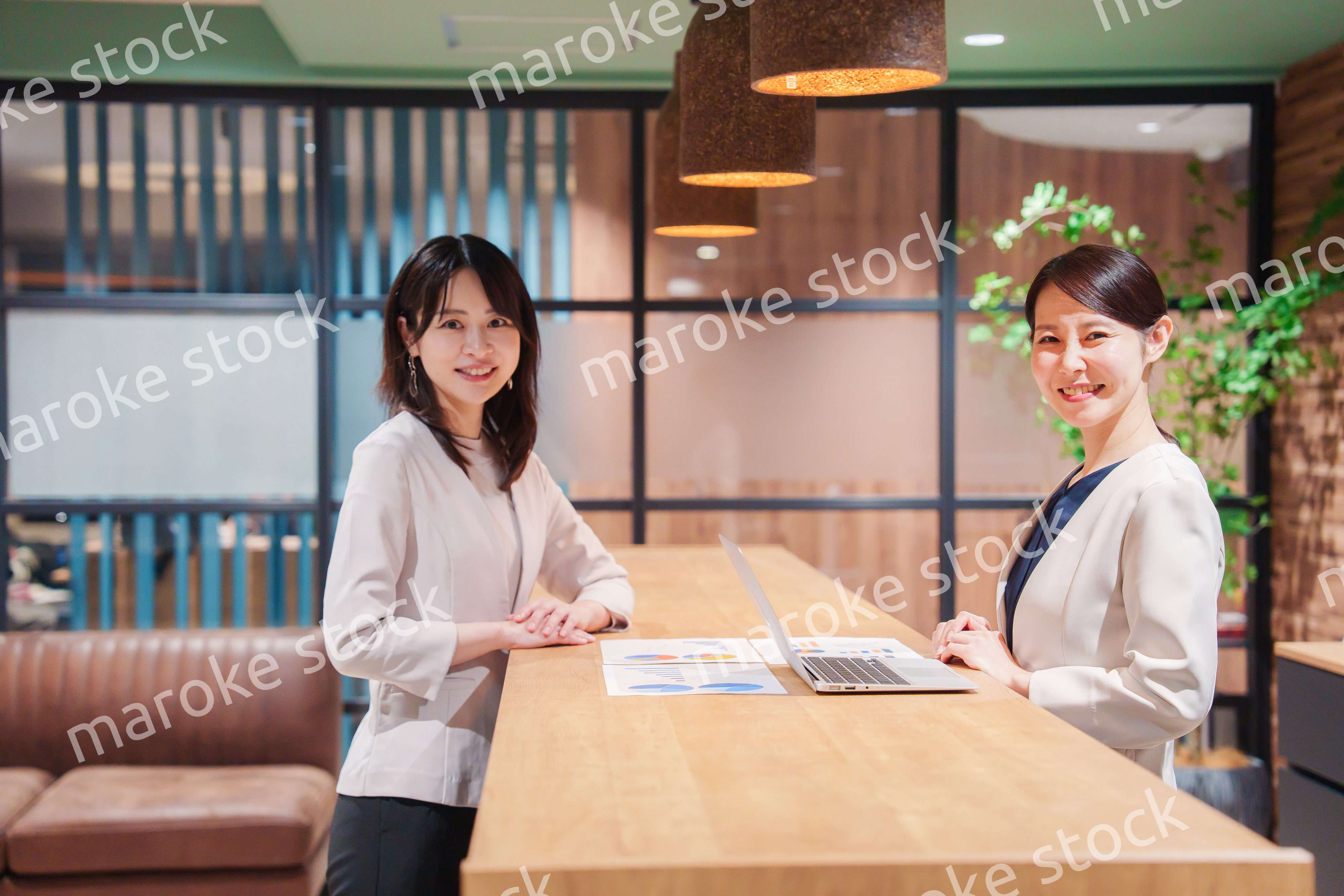 カメラ目線で笑顔の2人の働く女性