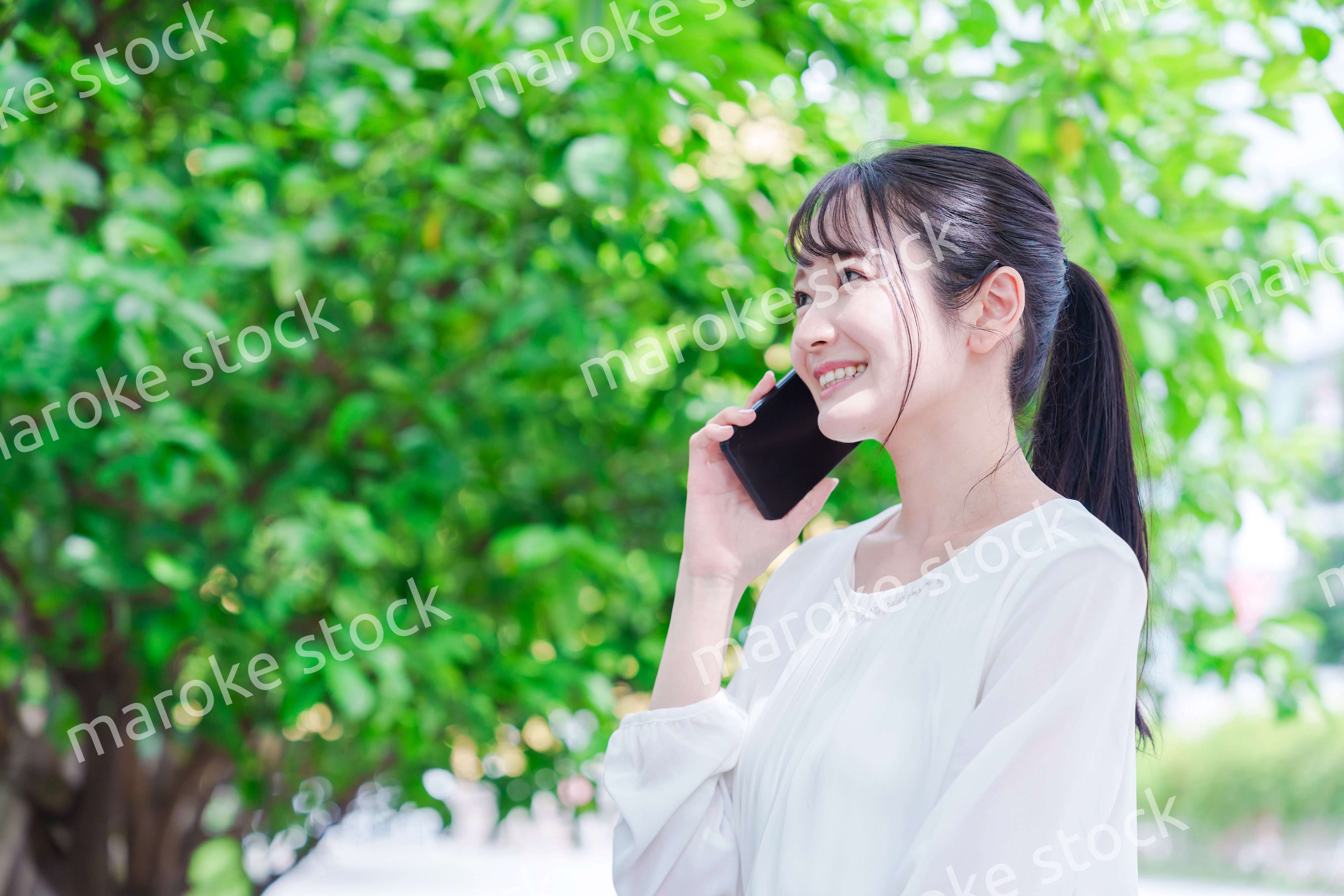 外で通話をする若い女性