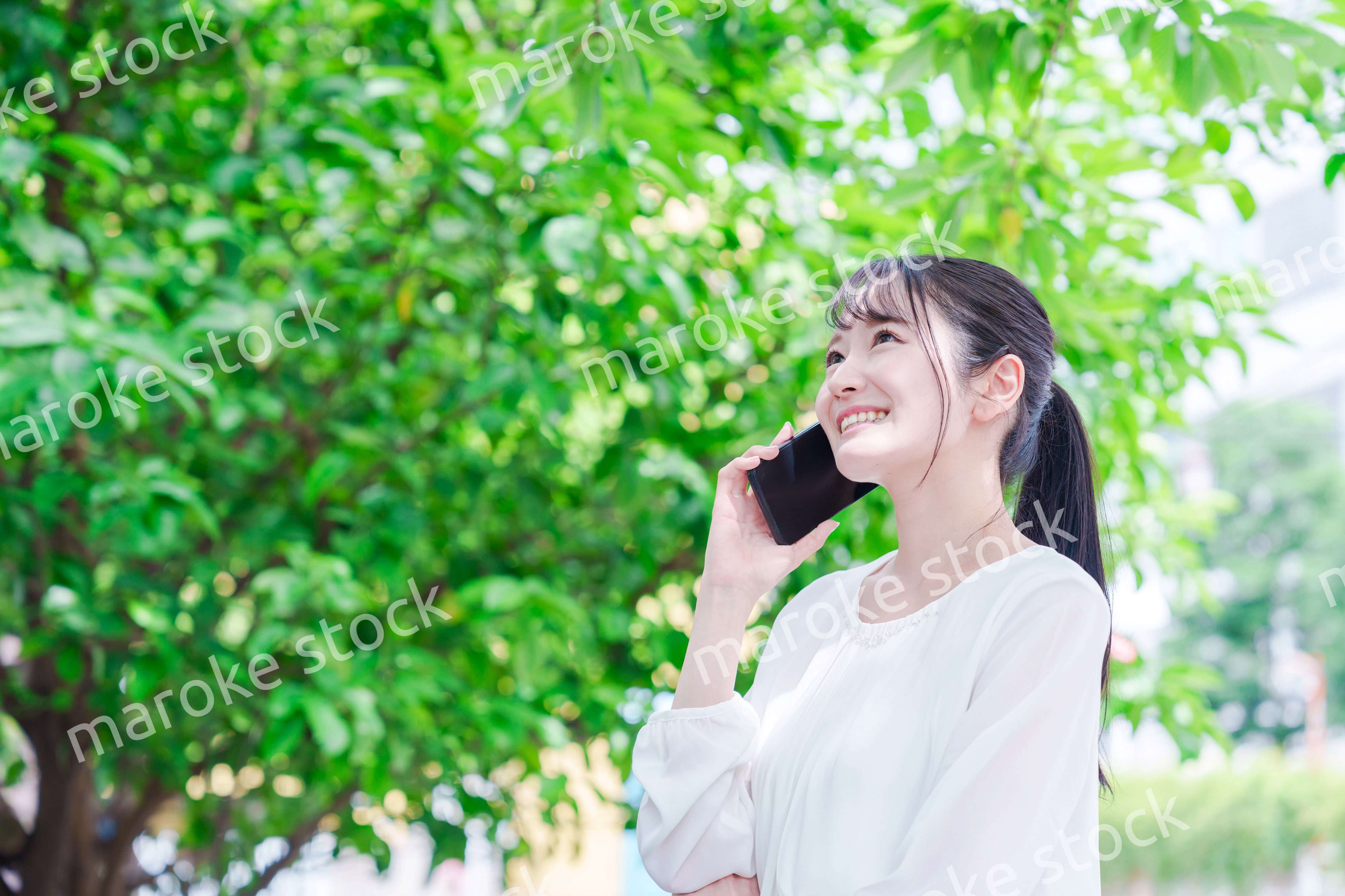 外で通話をする若い女性