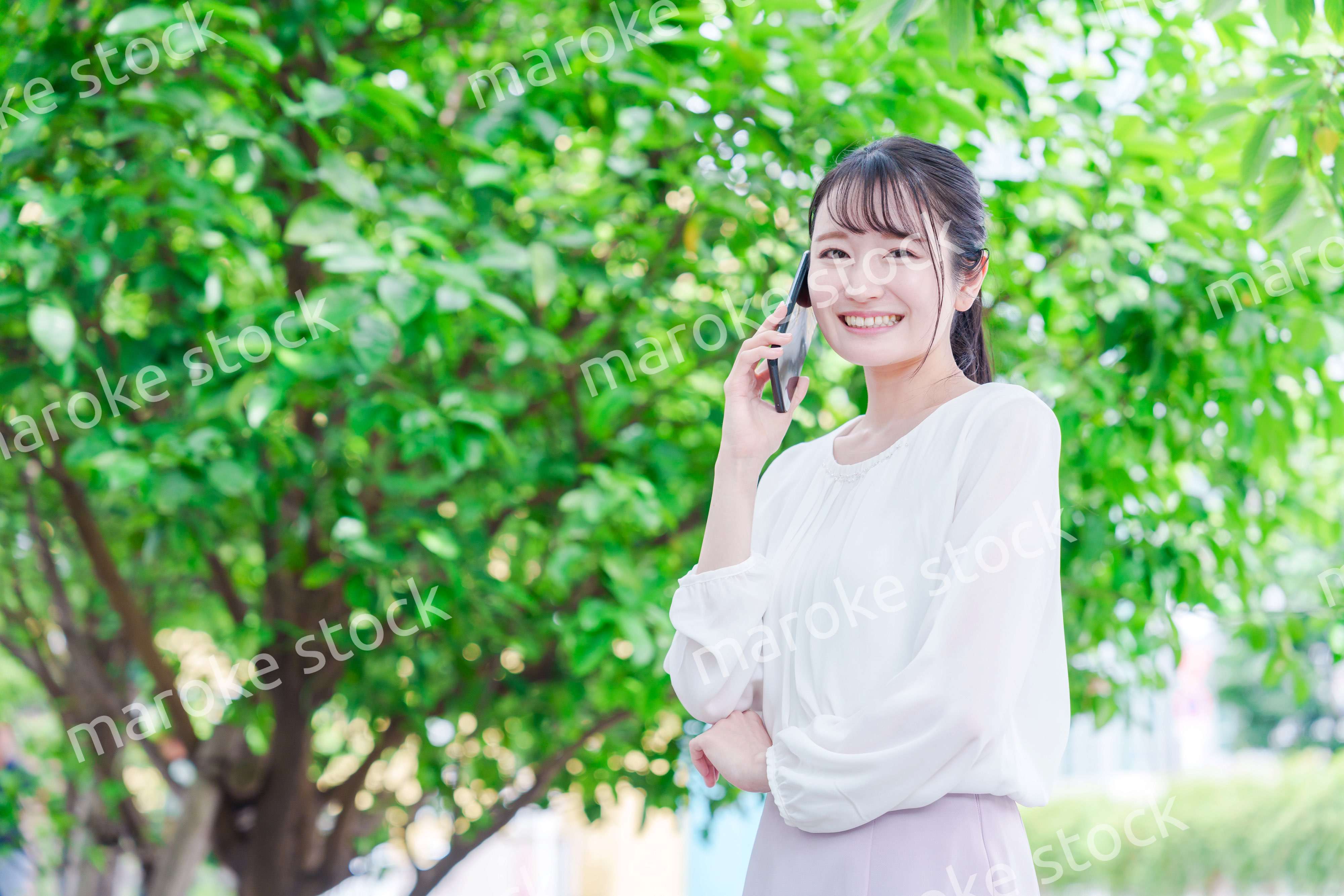 外で通話をする若い女性