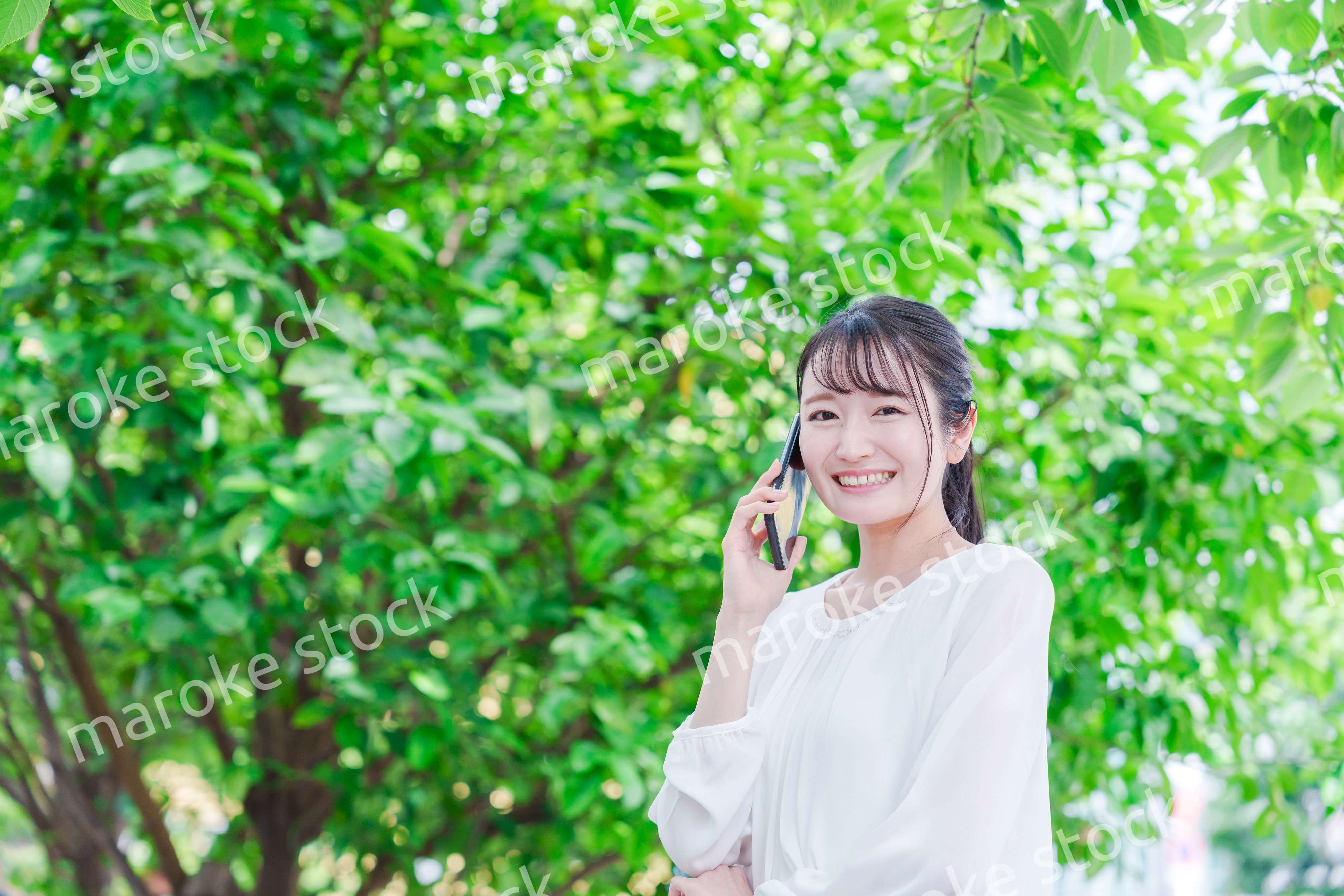 外で通話をする若い女性