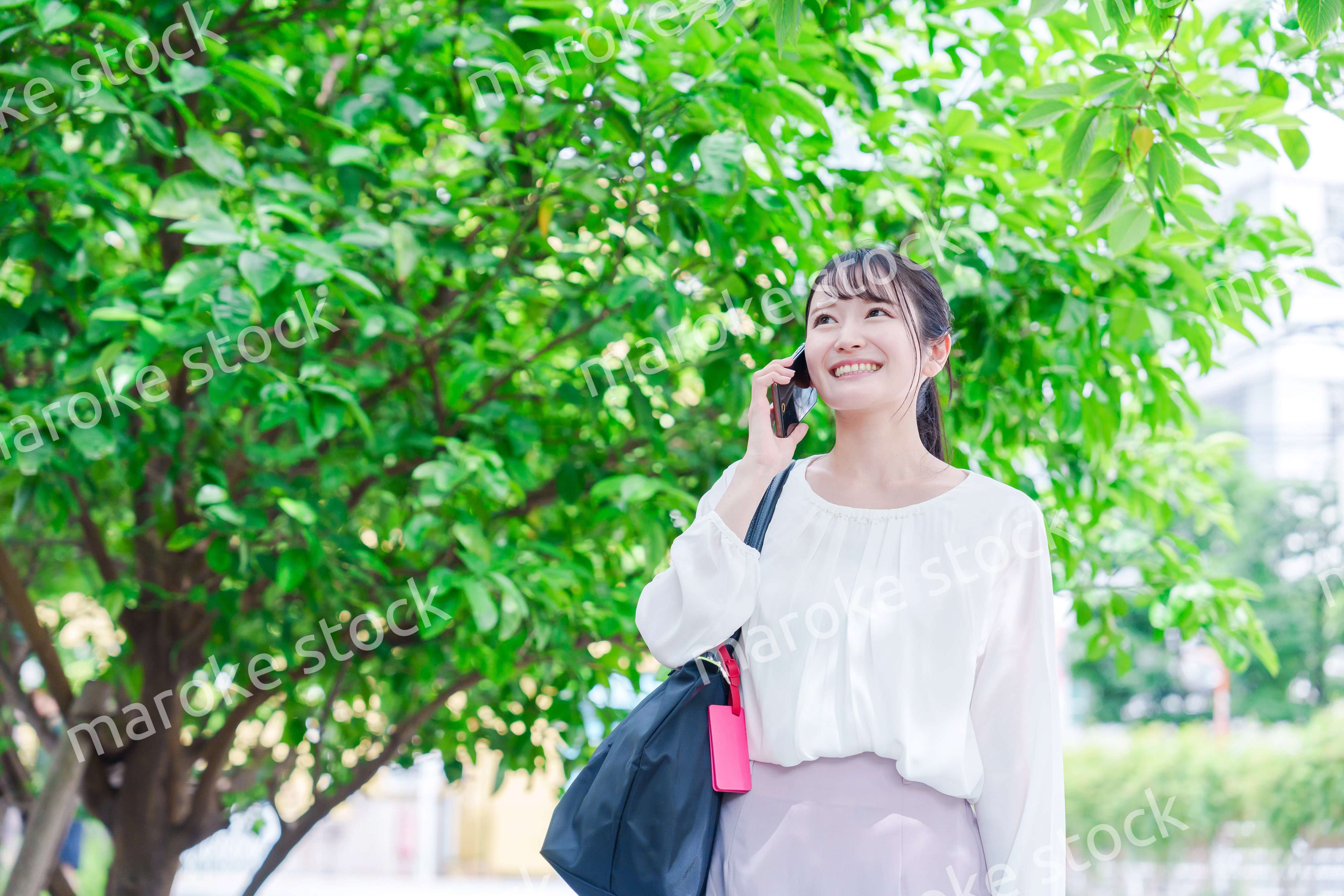 外で通話をする若い女性