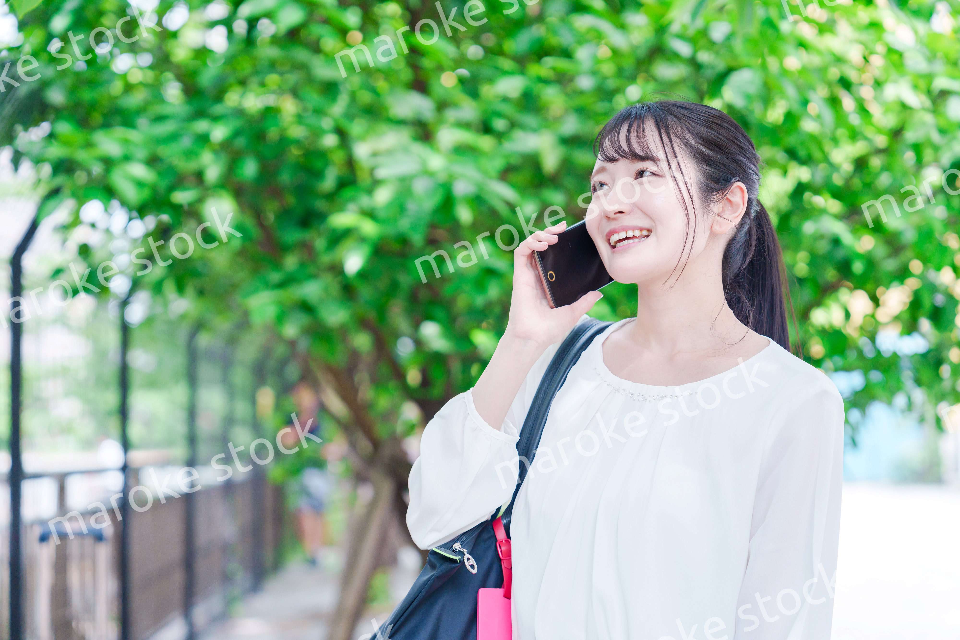 外で通話をする若い女性