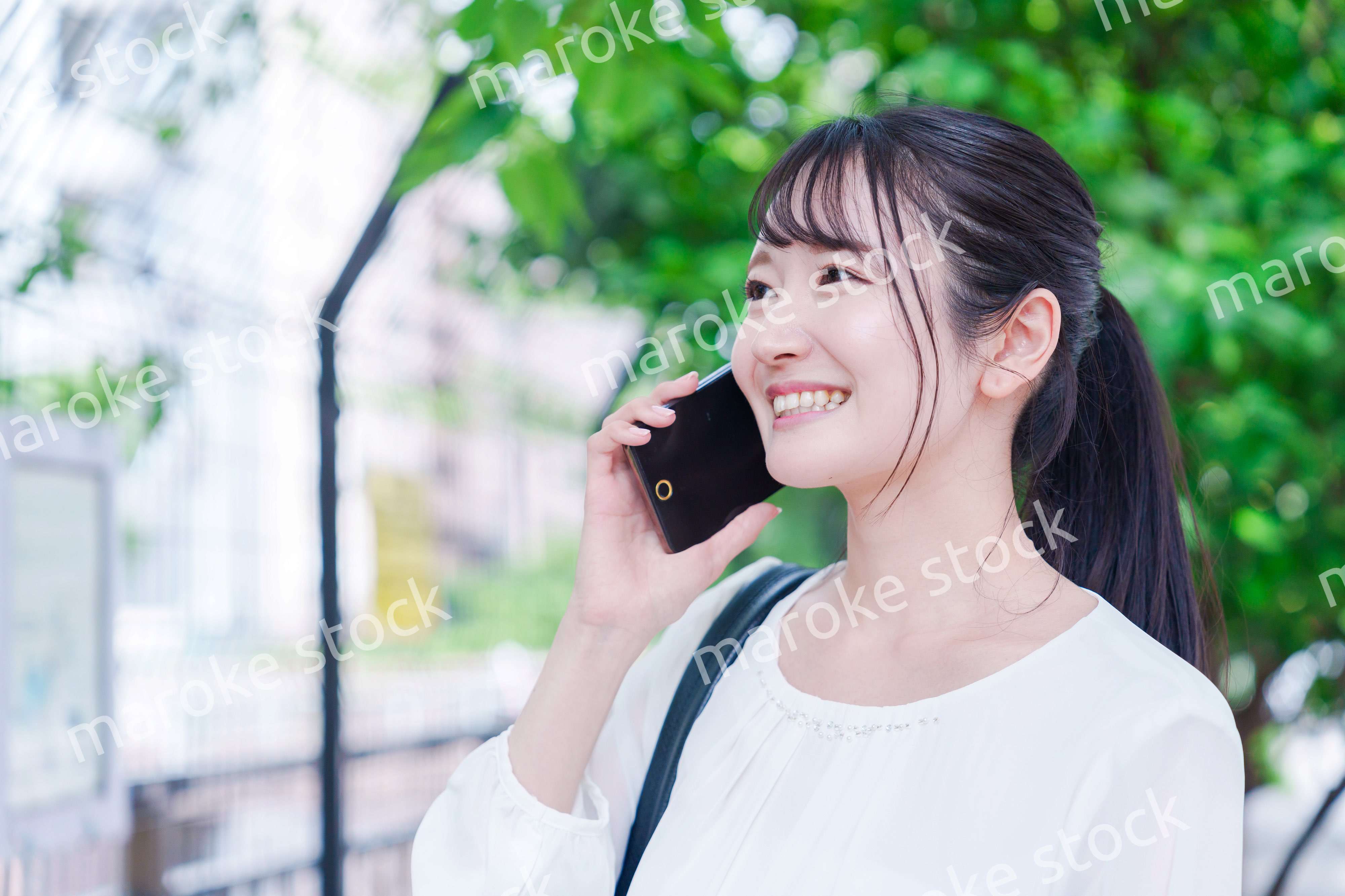 外で通話をする若い女性