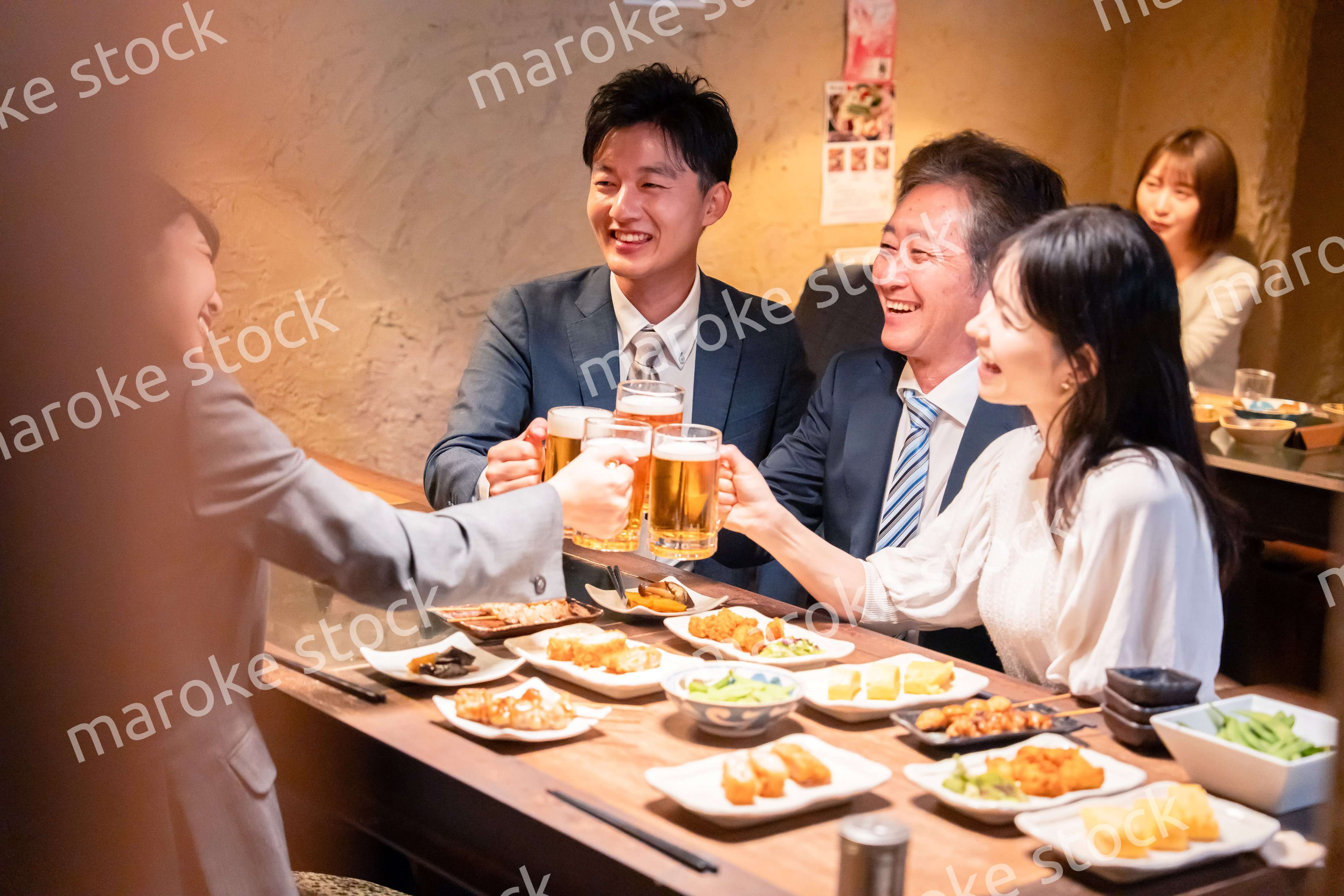 居酒屋で部署のお疲れ様会をするビジネスパーソン