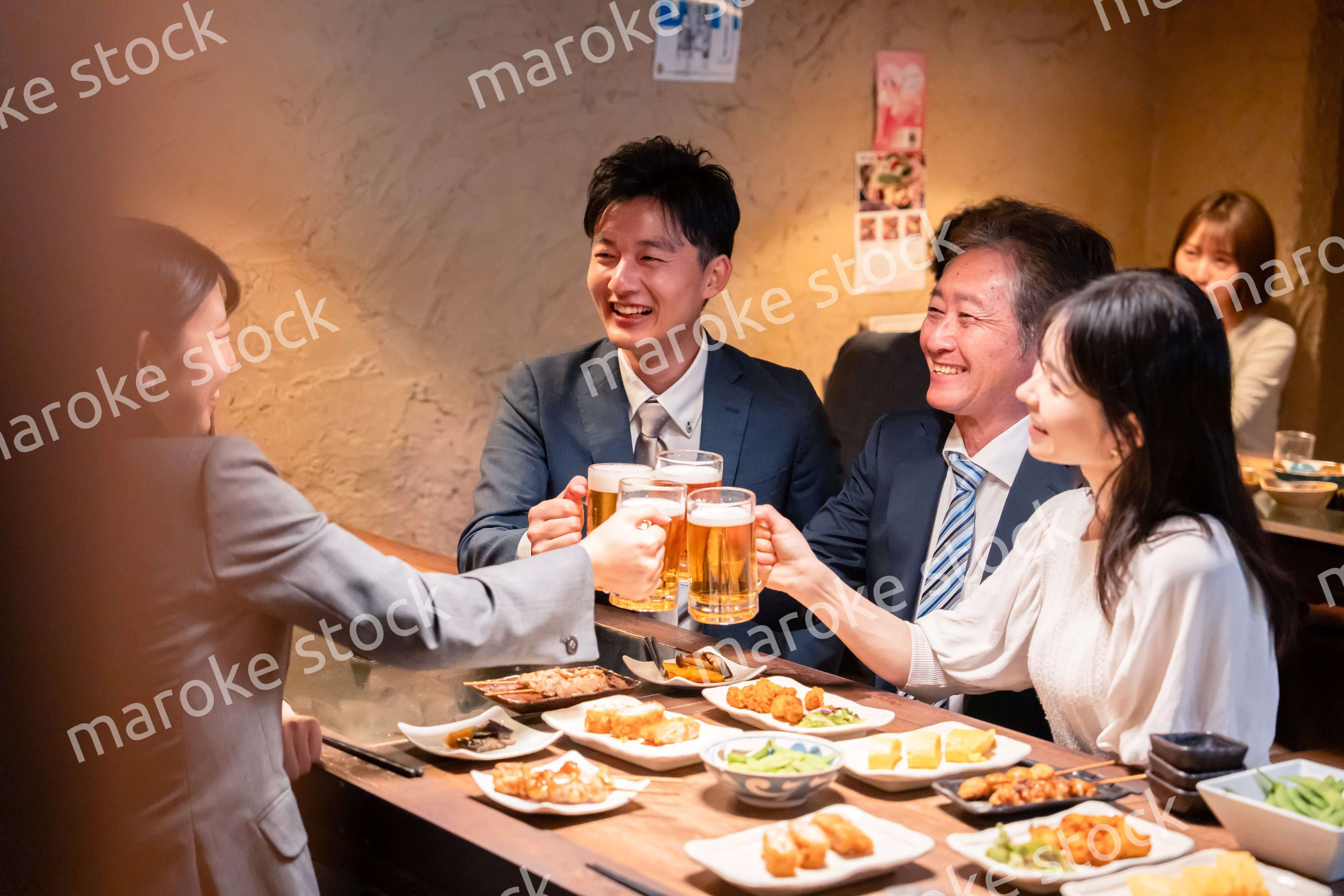 居酒屋で部署のお疲れ様会をするビジネスパーソン