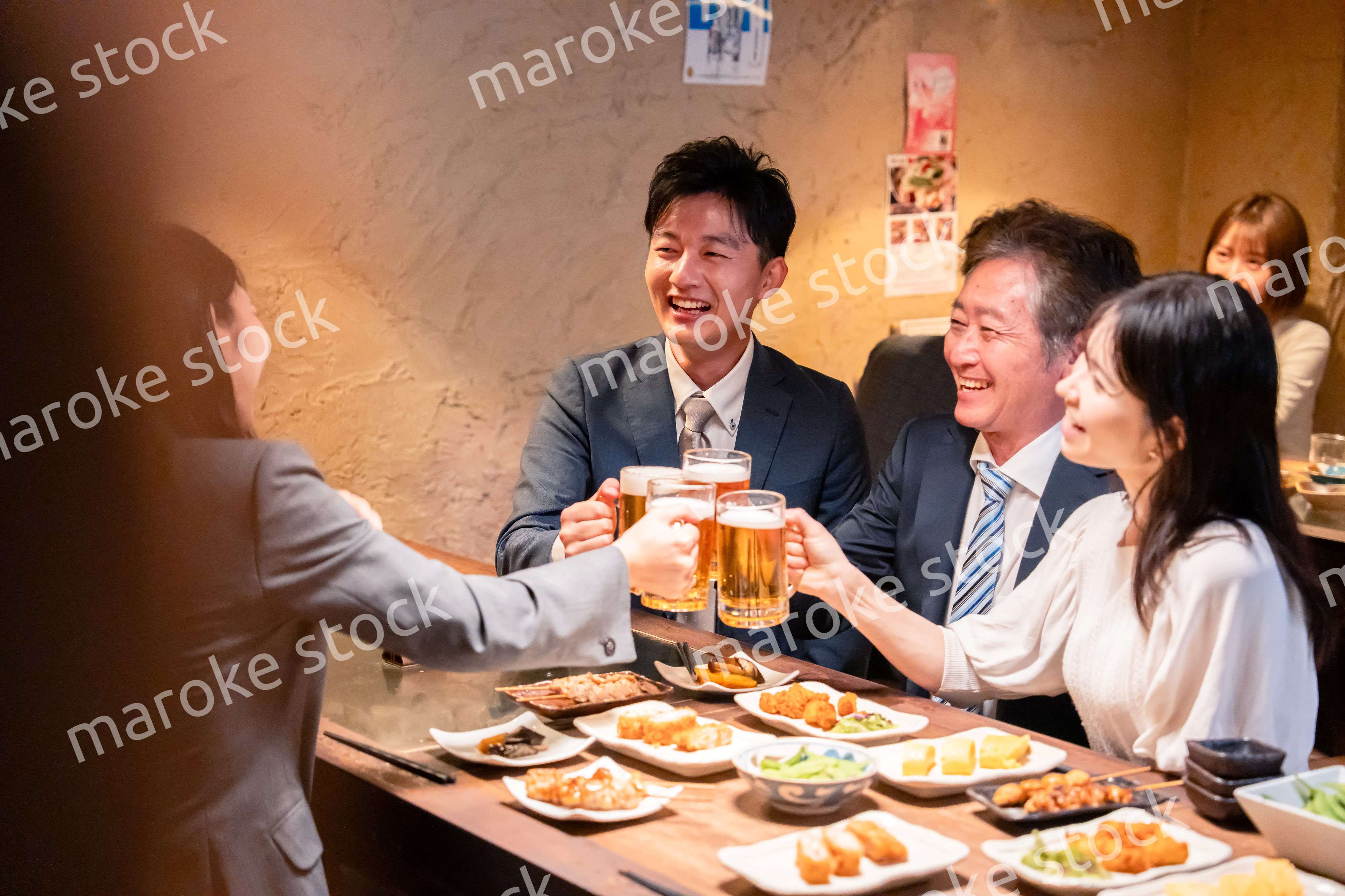 居酒屋で部署のお疲れ様会をするビジネスパーソン