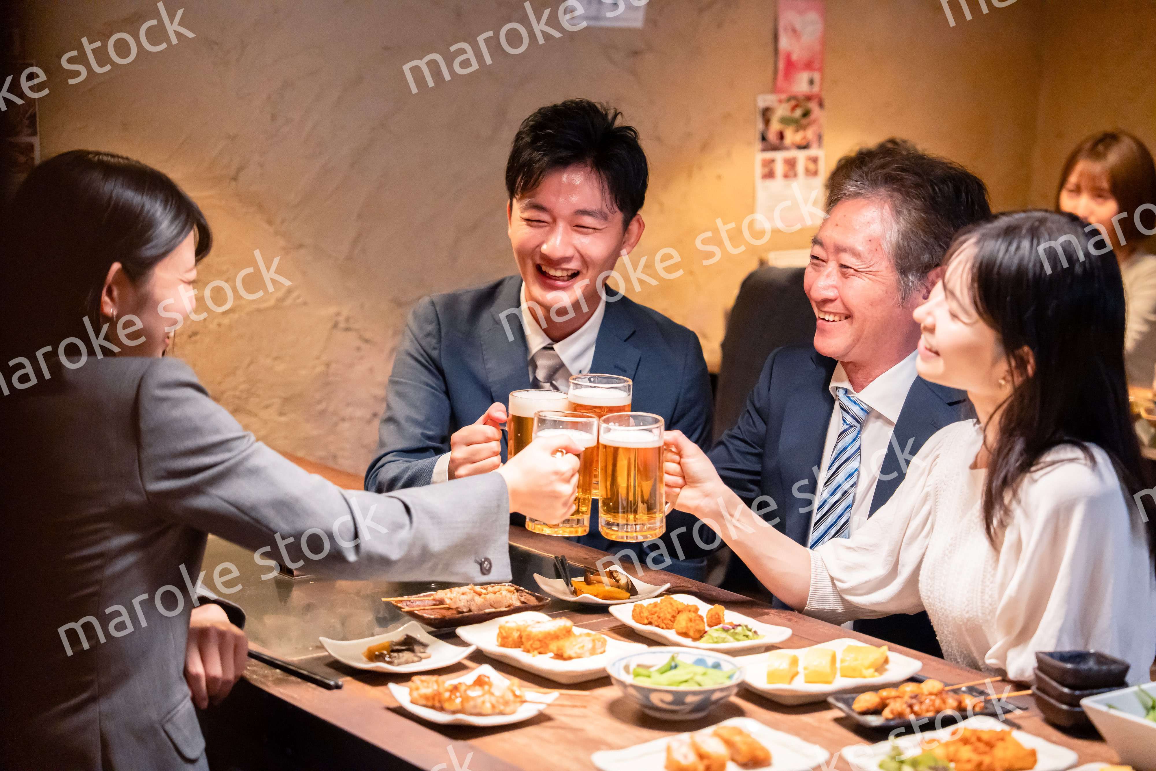 居酒屋で部署のお疲れ様会をするビジネスパーソン