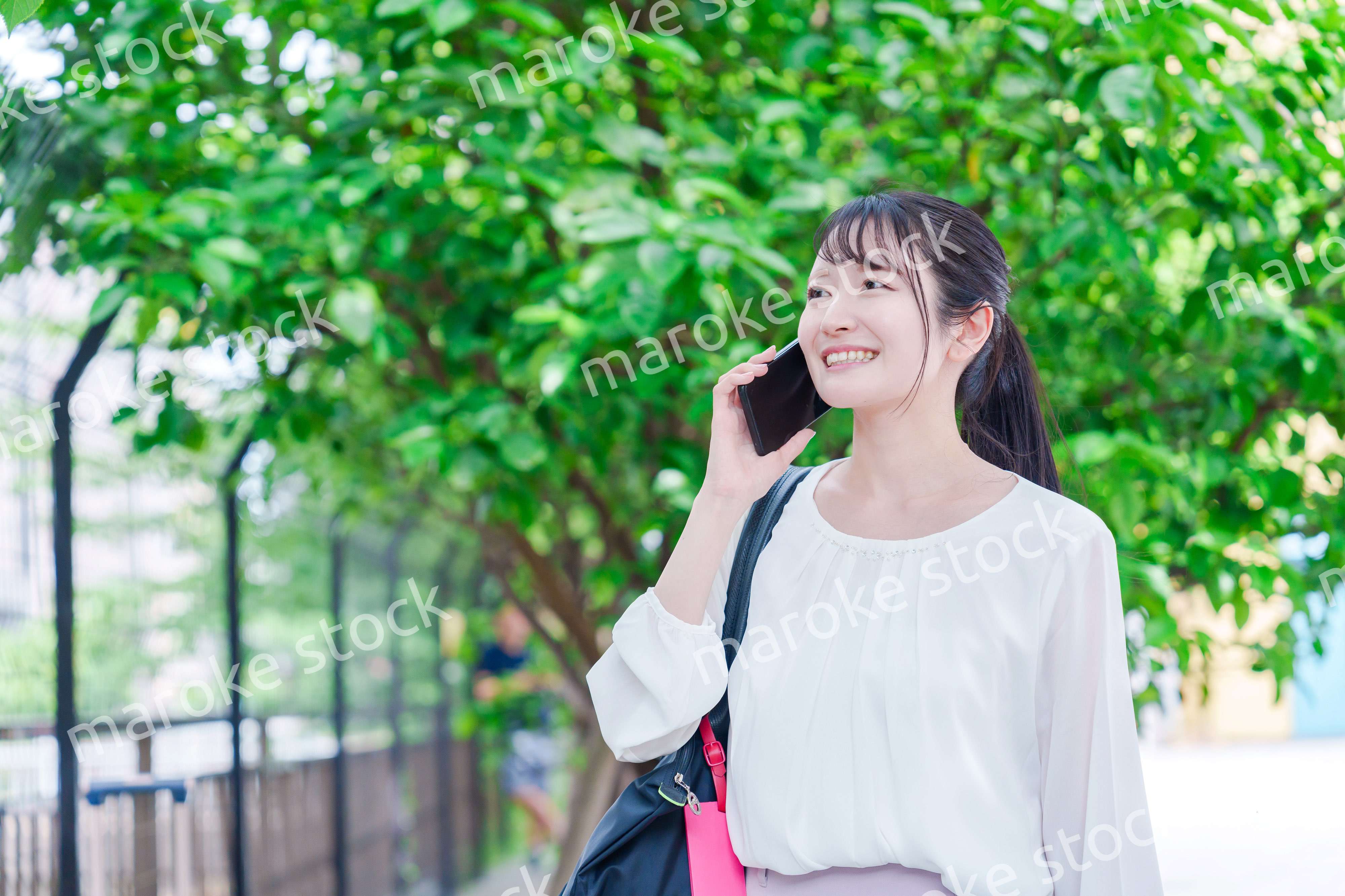 外で通話をする若い女性