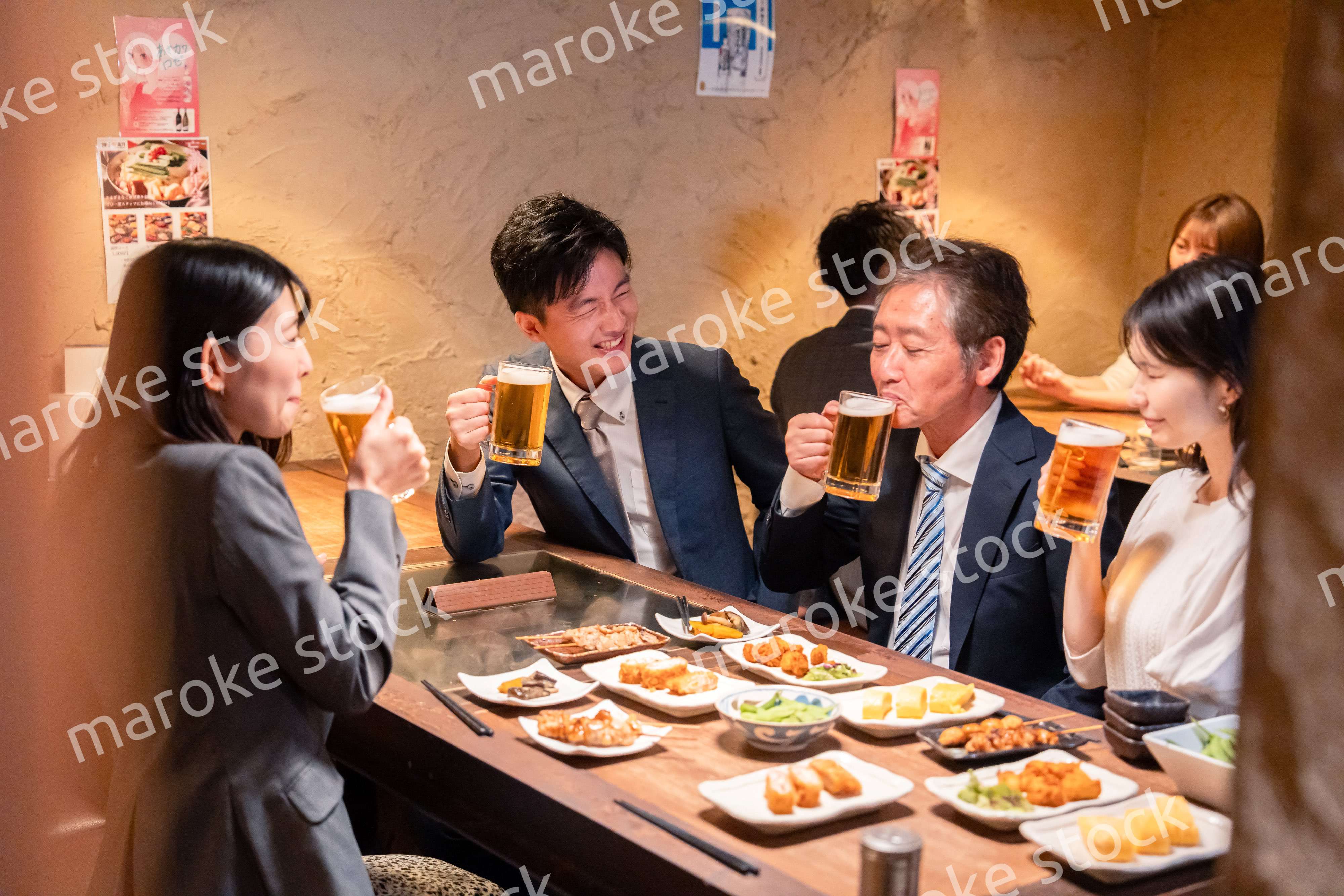 居酒屋で部署のお疲れ様会をするビジネスパーソン