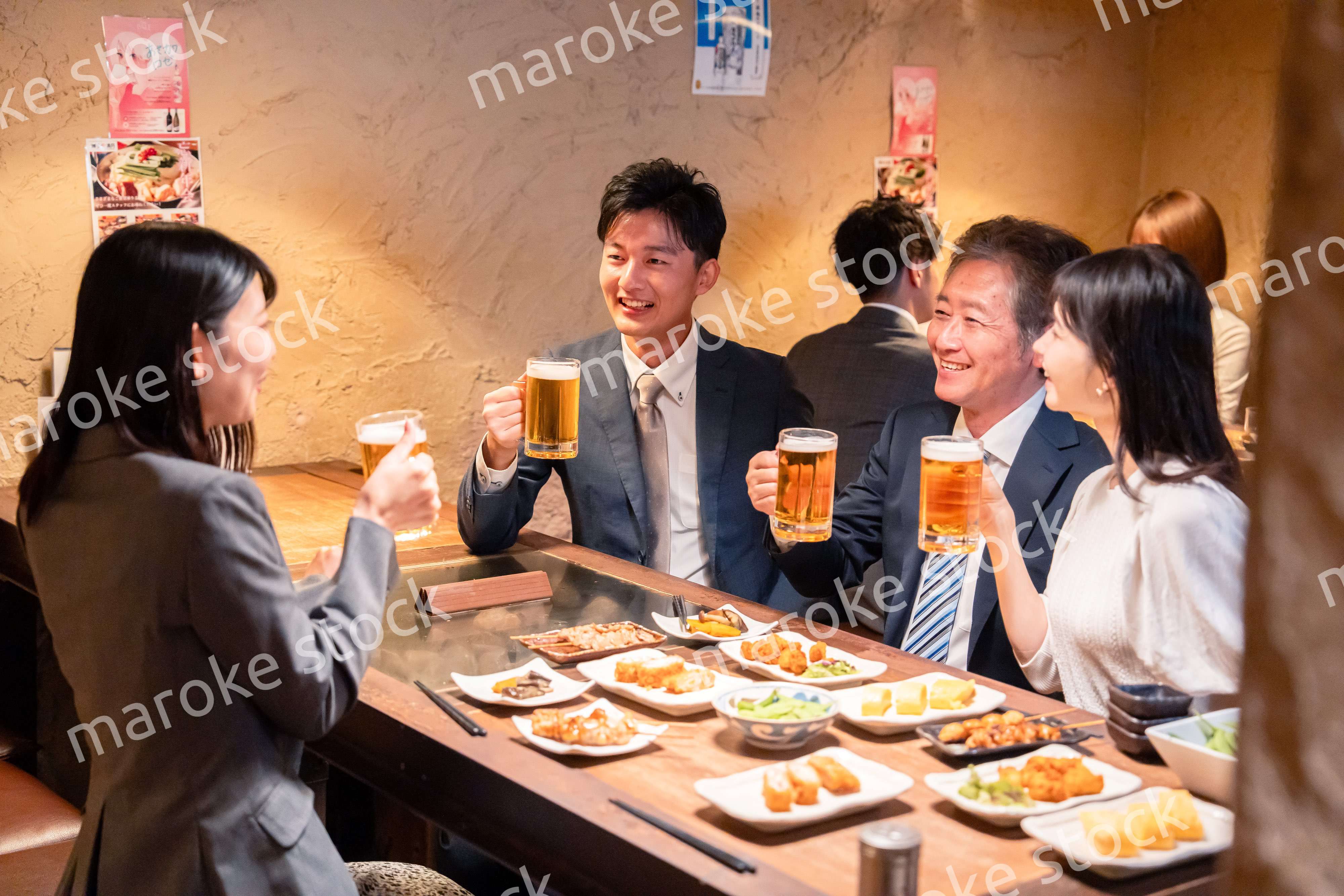 居酒屋で部署のお疲れ様会をするビジネスパーソン