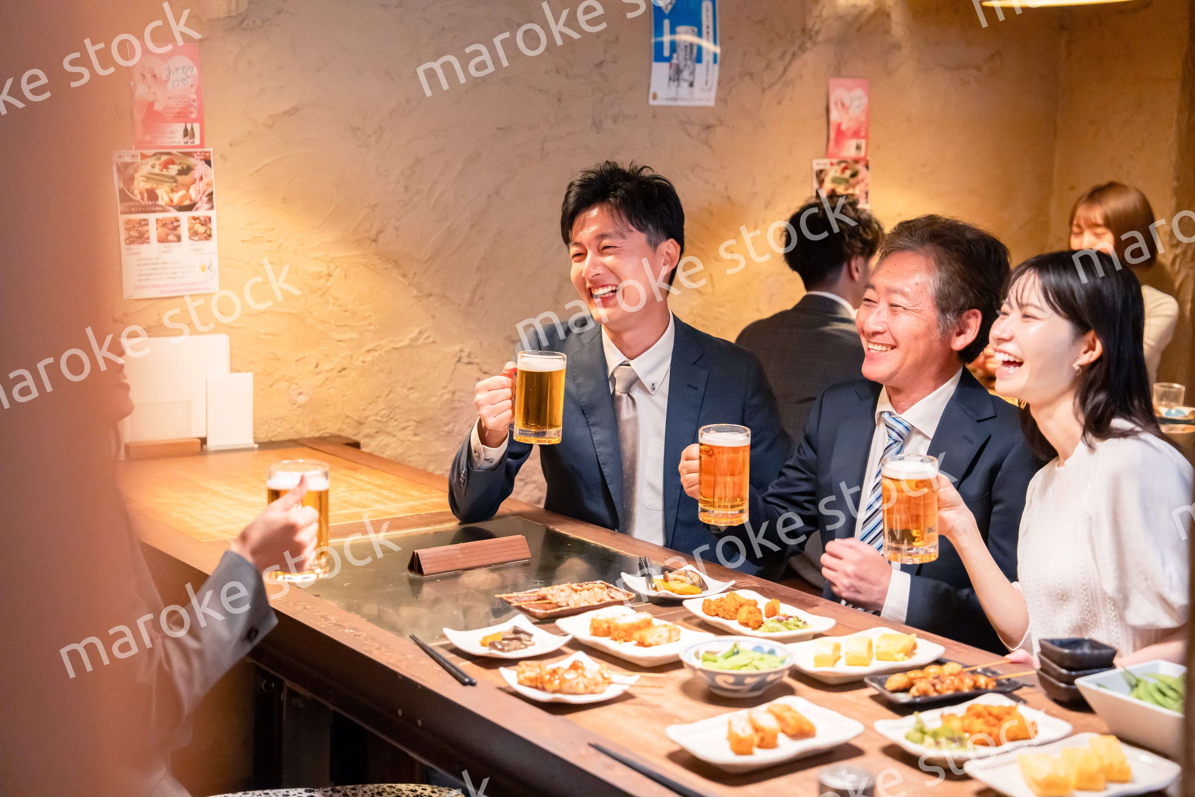 居酒屋で部署のお疲れ様会をするビジネスパーソン