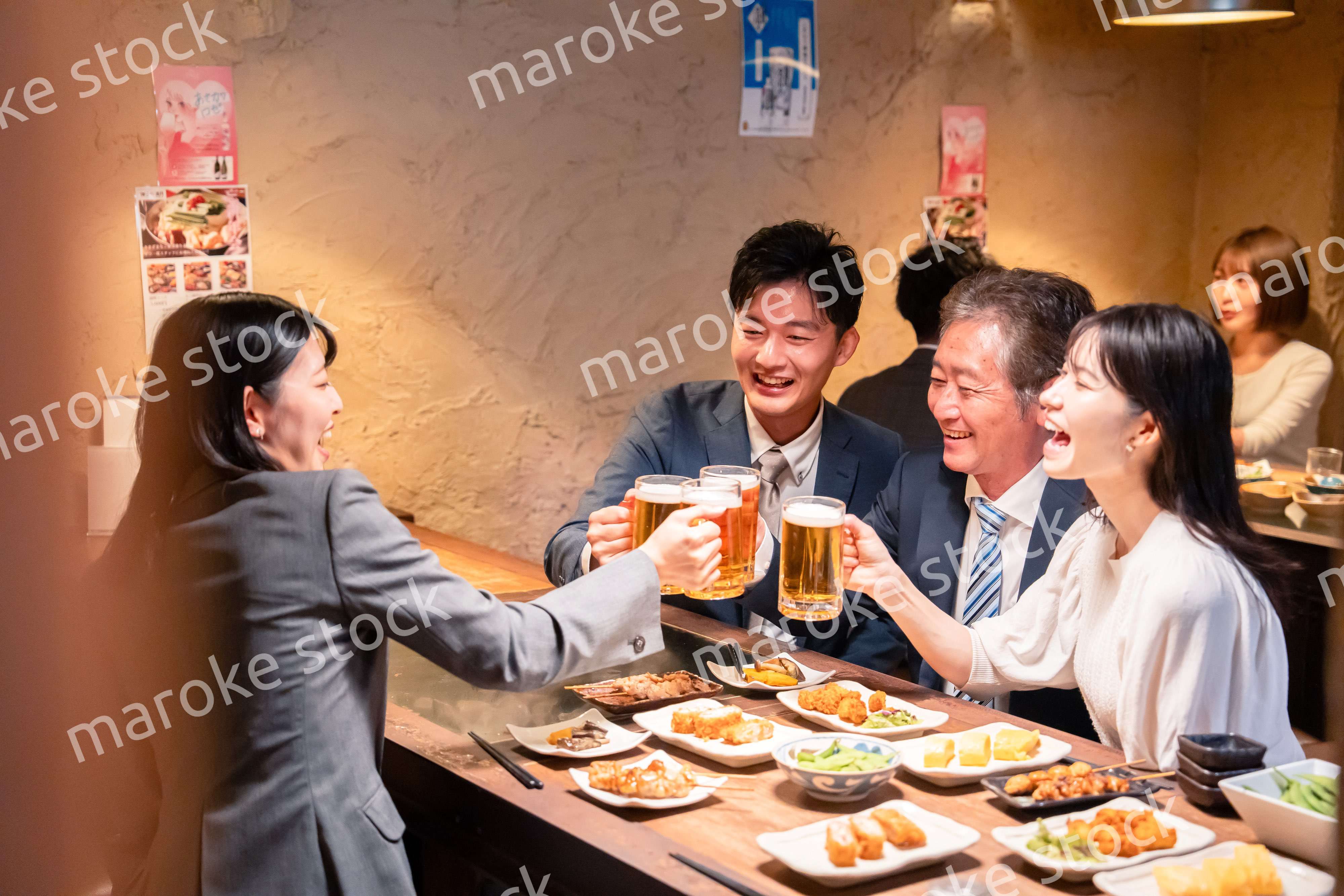 居酒屋で部署のお疲れ様会をするビジネスパーソン