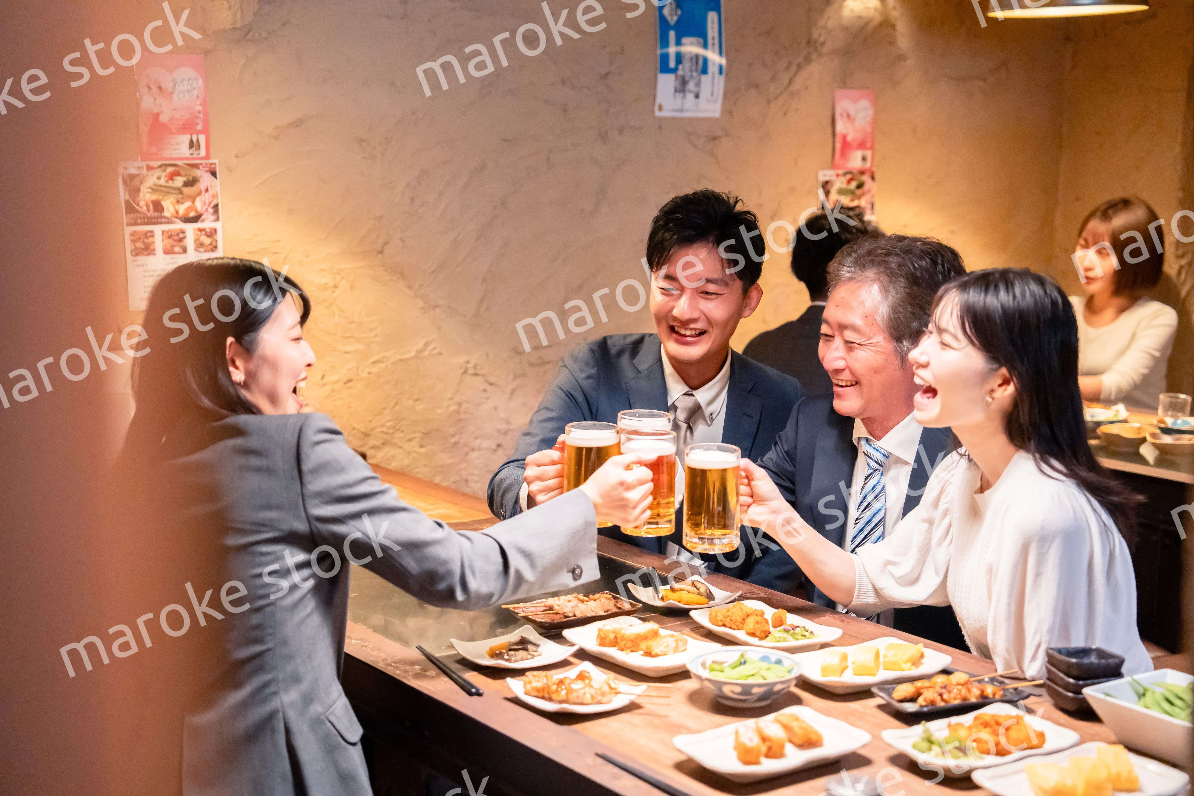居酒屋で部署のお疲れ様会をするビジネスパーソン