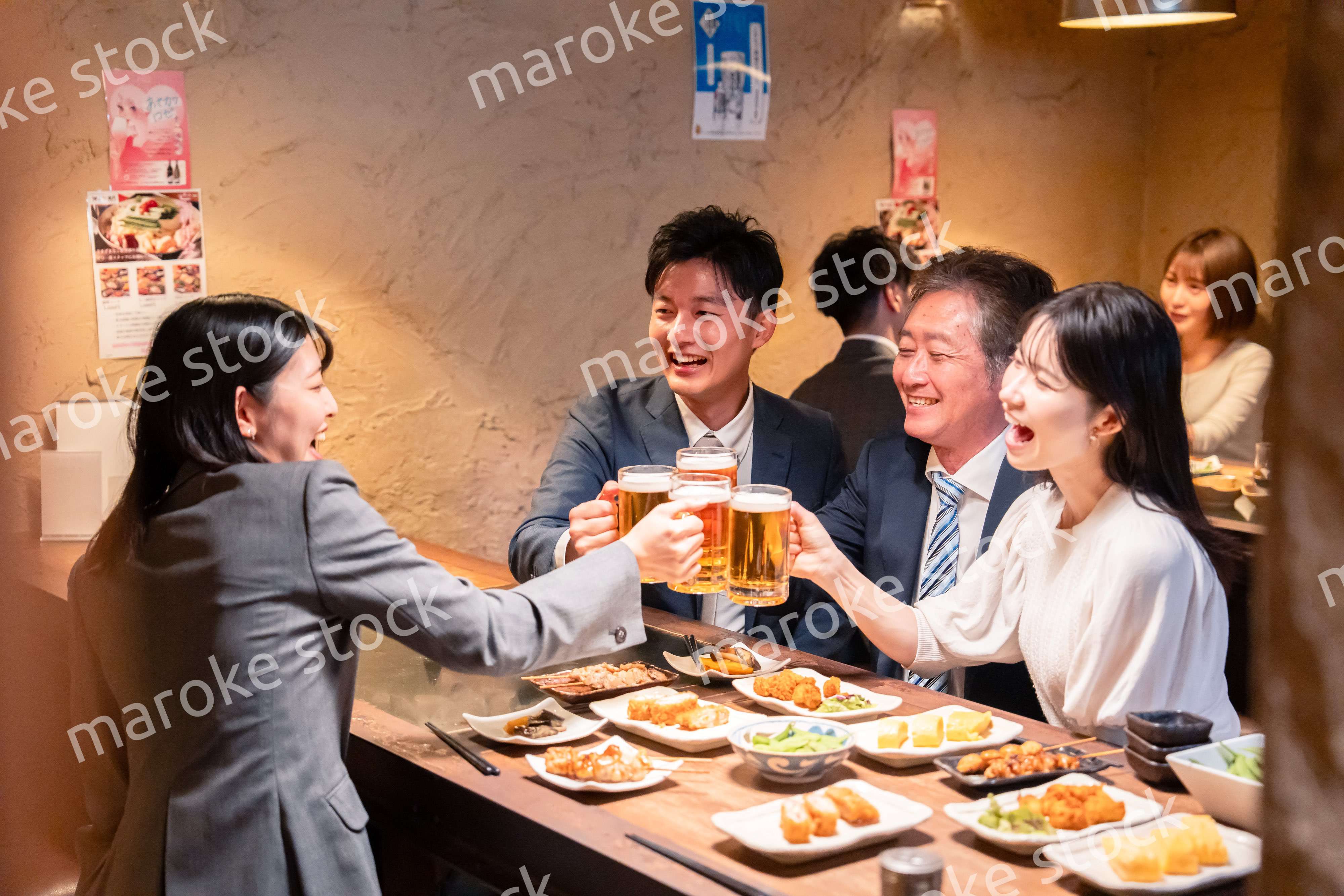 居酒屋で部署のお疲れ様会をするビジネスパーソン