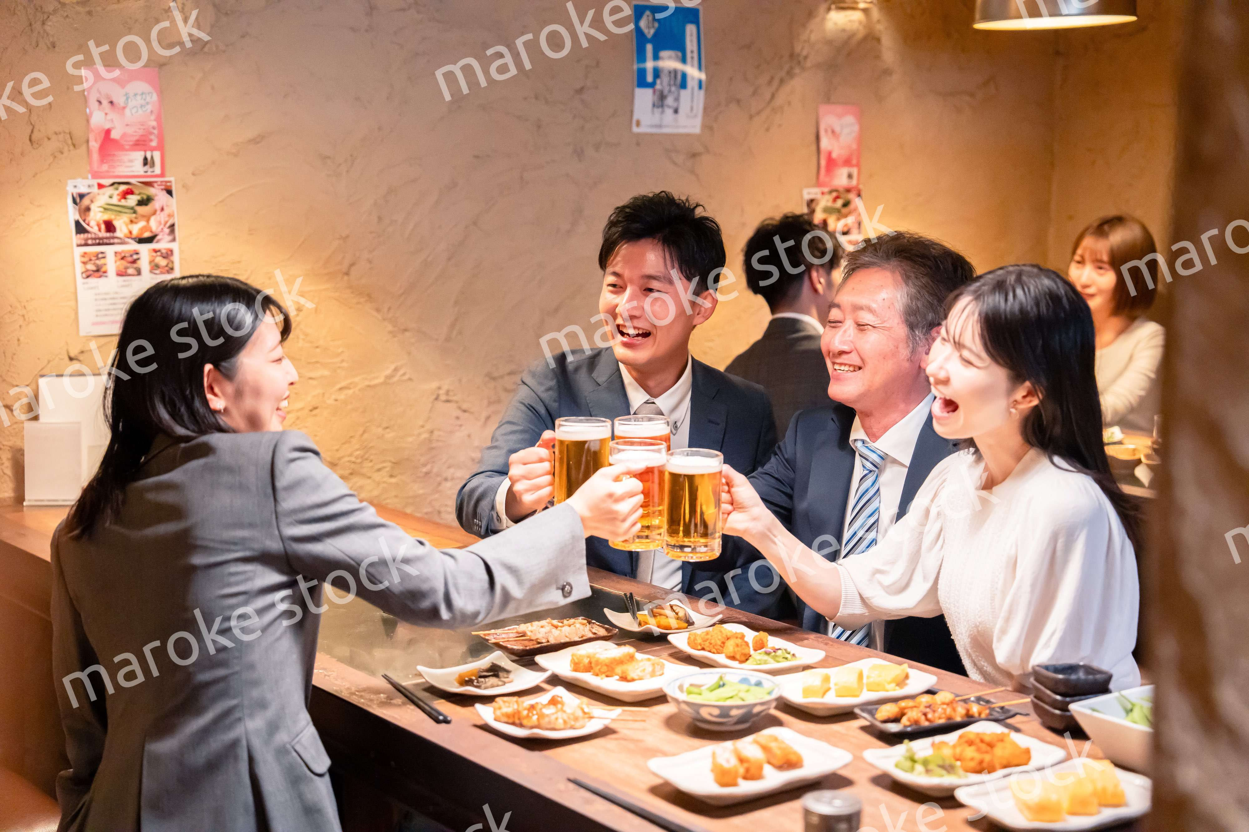 居酒屋で部署のお疲れ様会をするビジネスパーソン