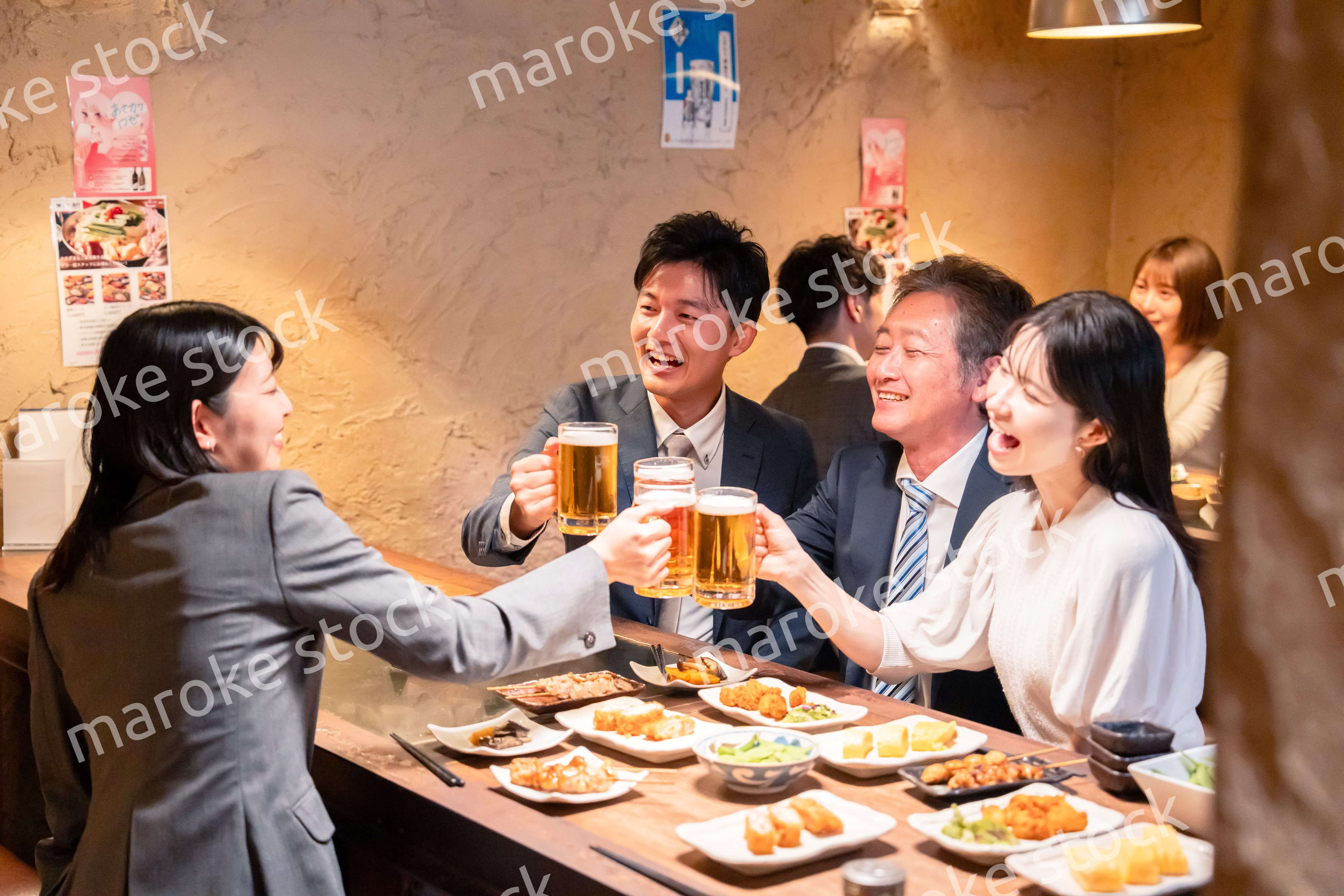 居酒屋で部署のお疲れ様会をするビジネスパーソン