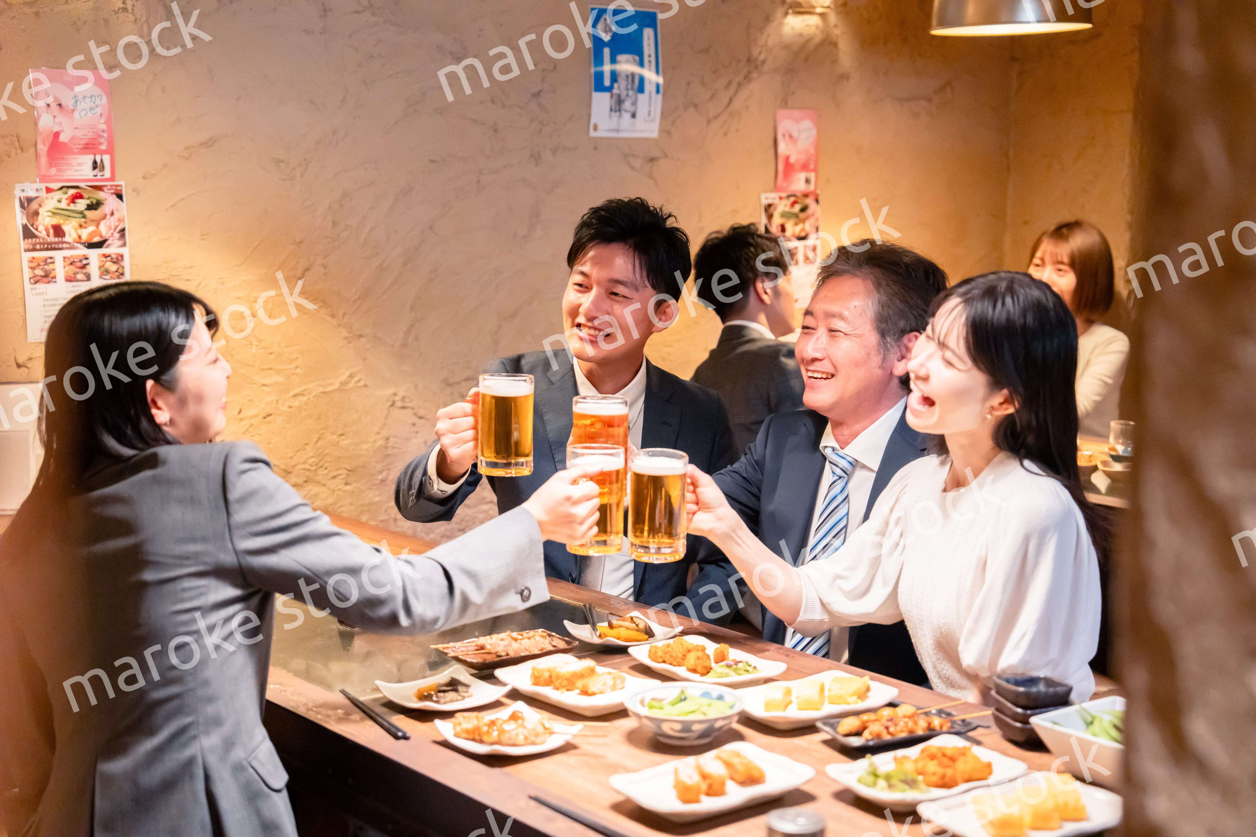居酒屋で部署のお疲れ様会をするビジネスパーソン