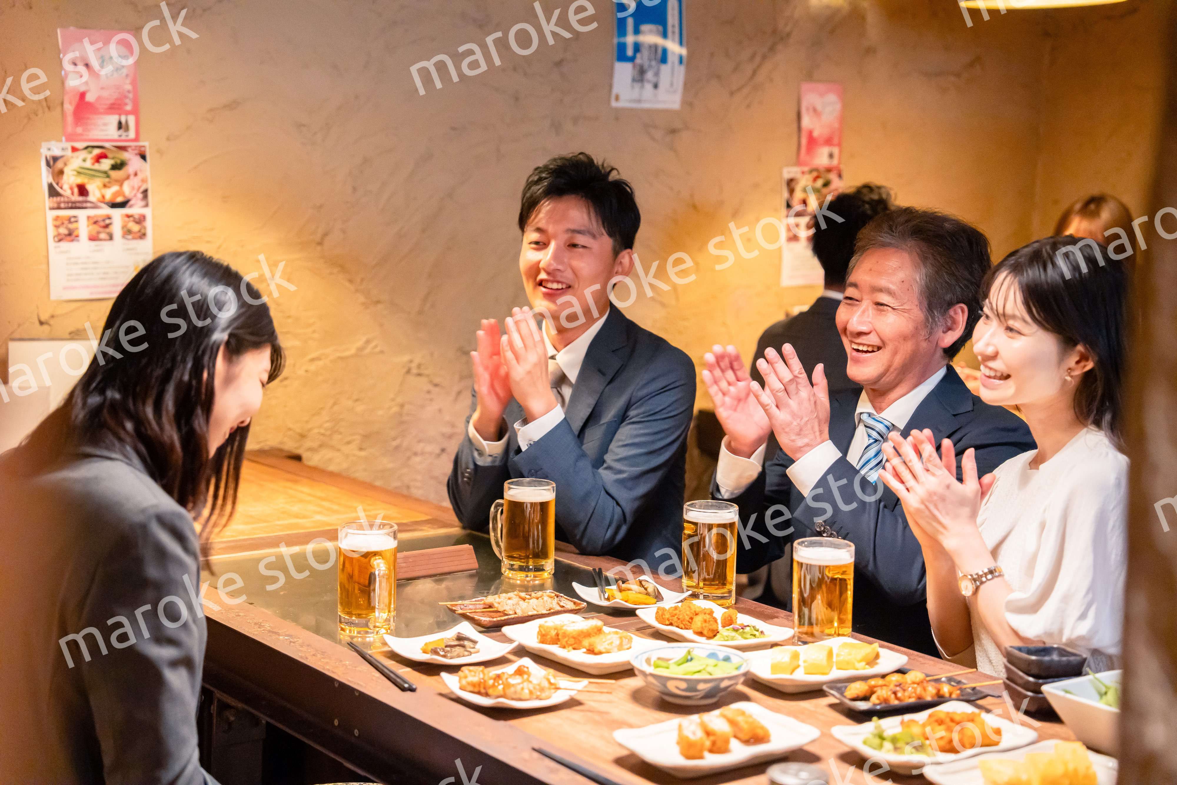 居酒屋でお祝いをするビジネスパーソン