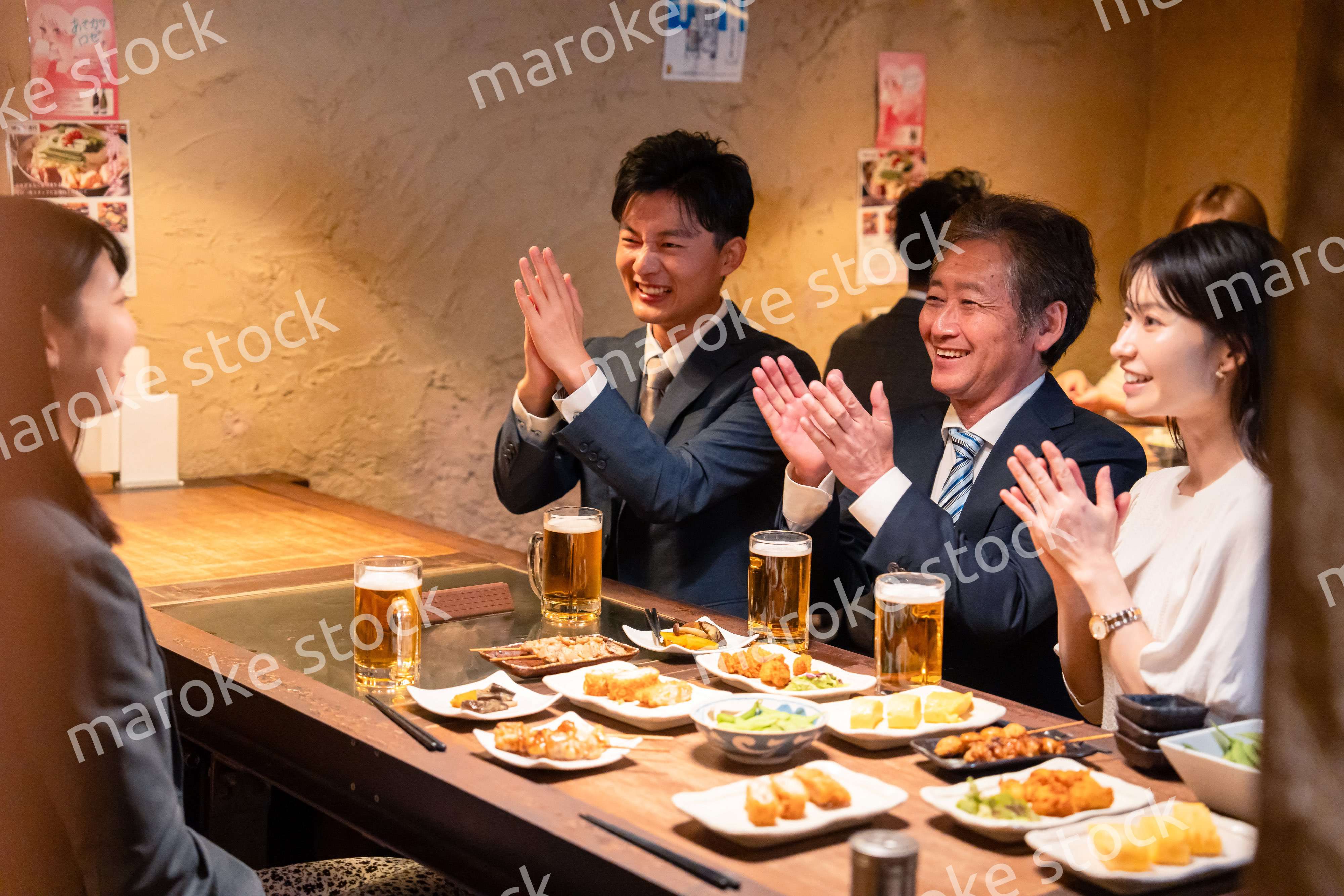 居酒屋でお祝いをするビジネスパーソン