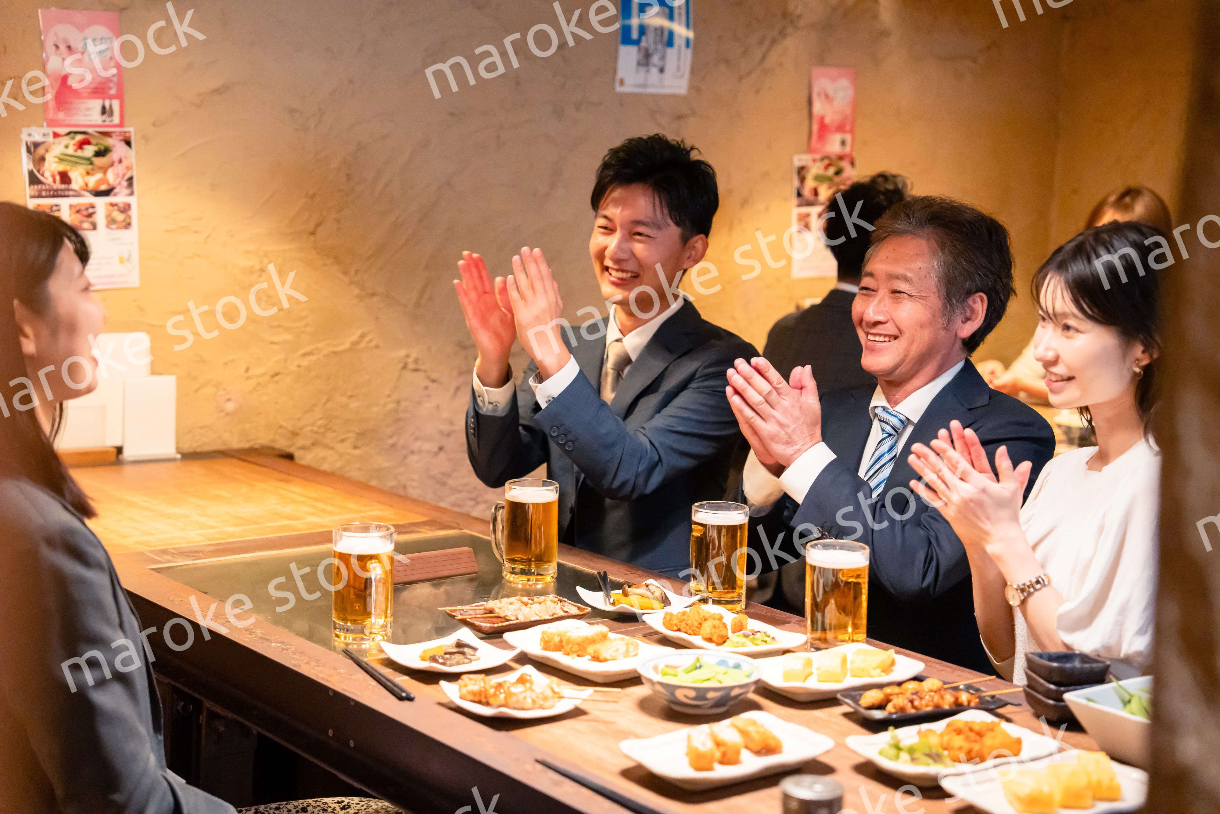 居酒屋でお祝いをするビジネスパーソン