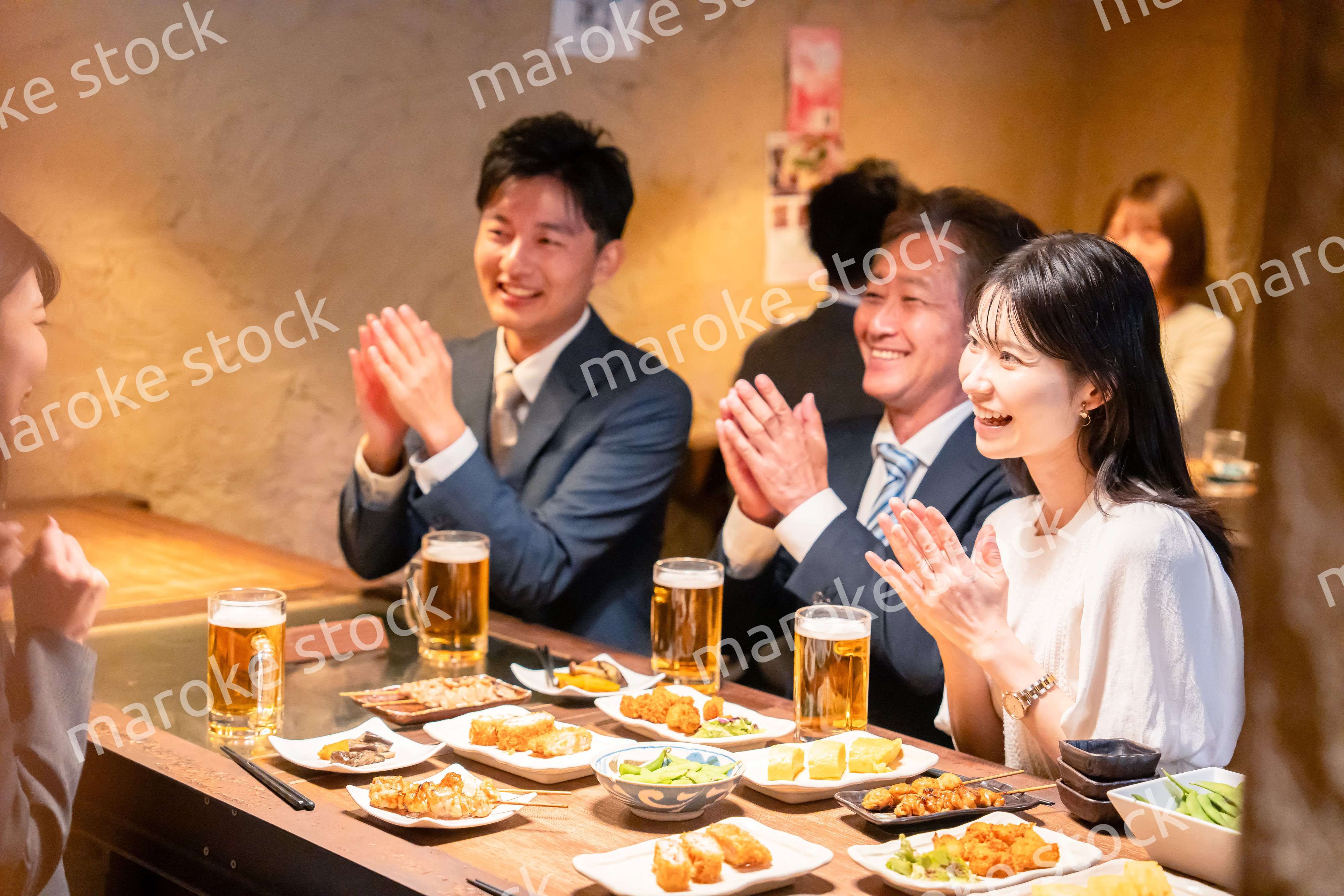 居酒屋でお祝いをするビジネスパーソン