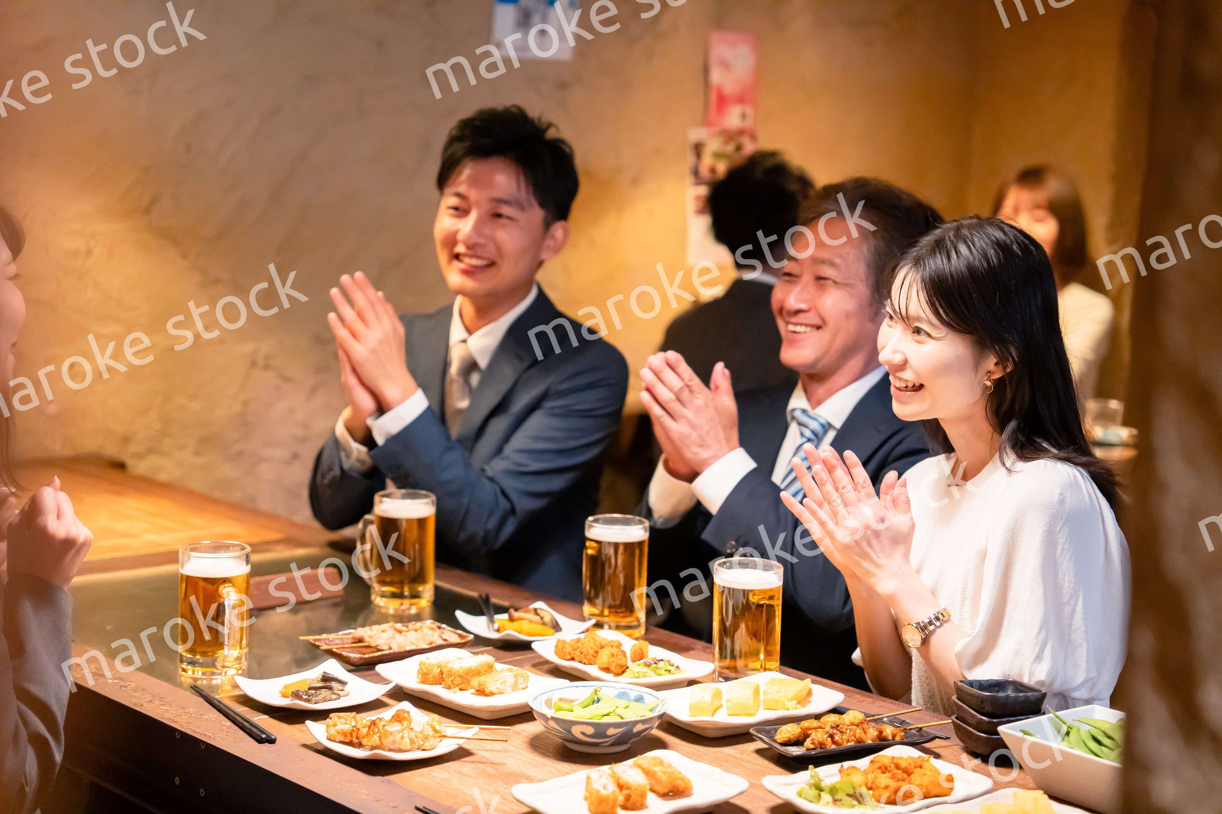 居酒屋でお祝いをするビジネスパーソン