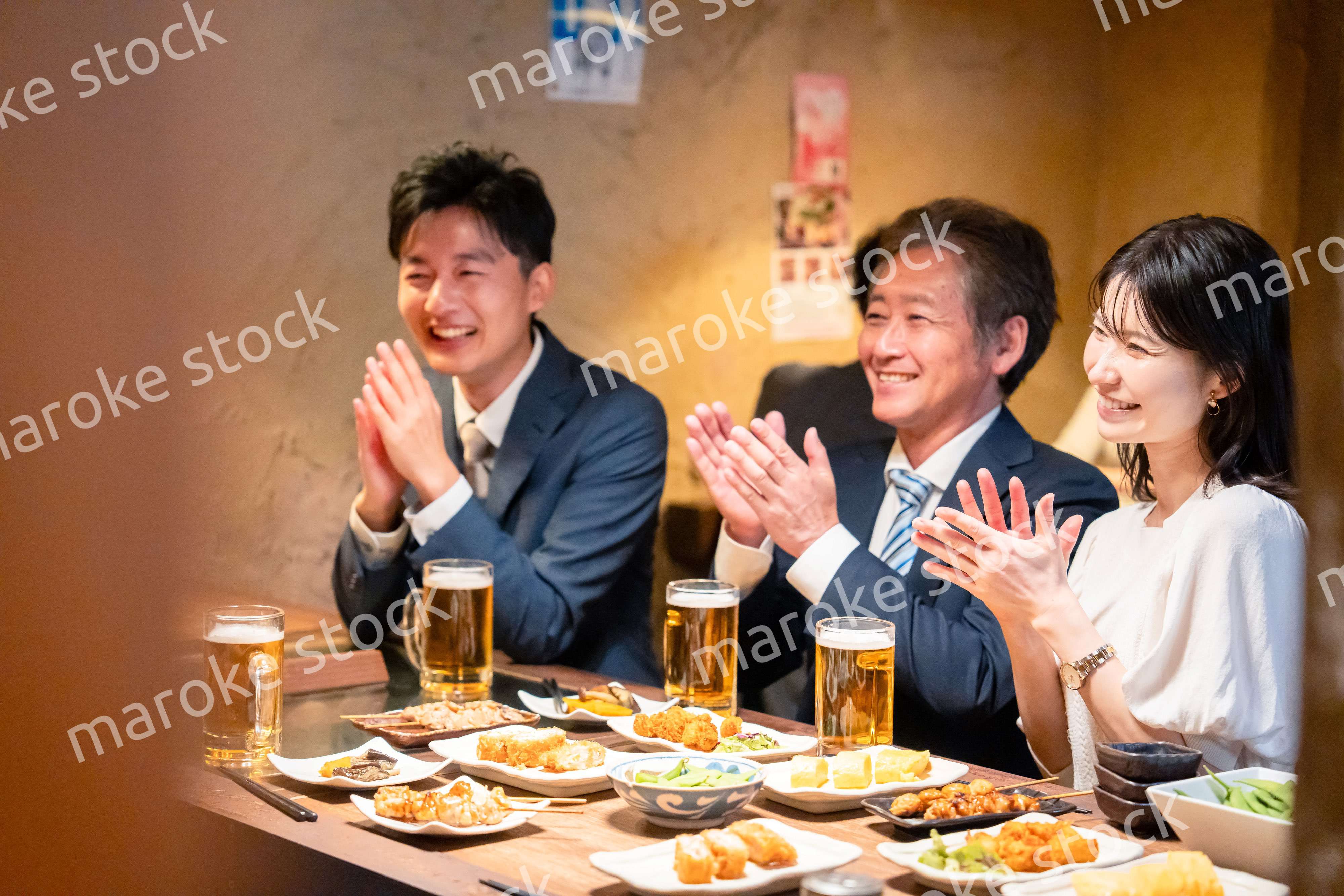 居酒屋でお祝いをするビジネスパーソン