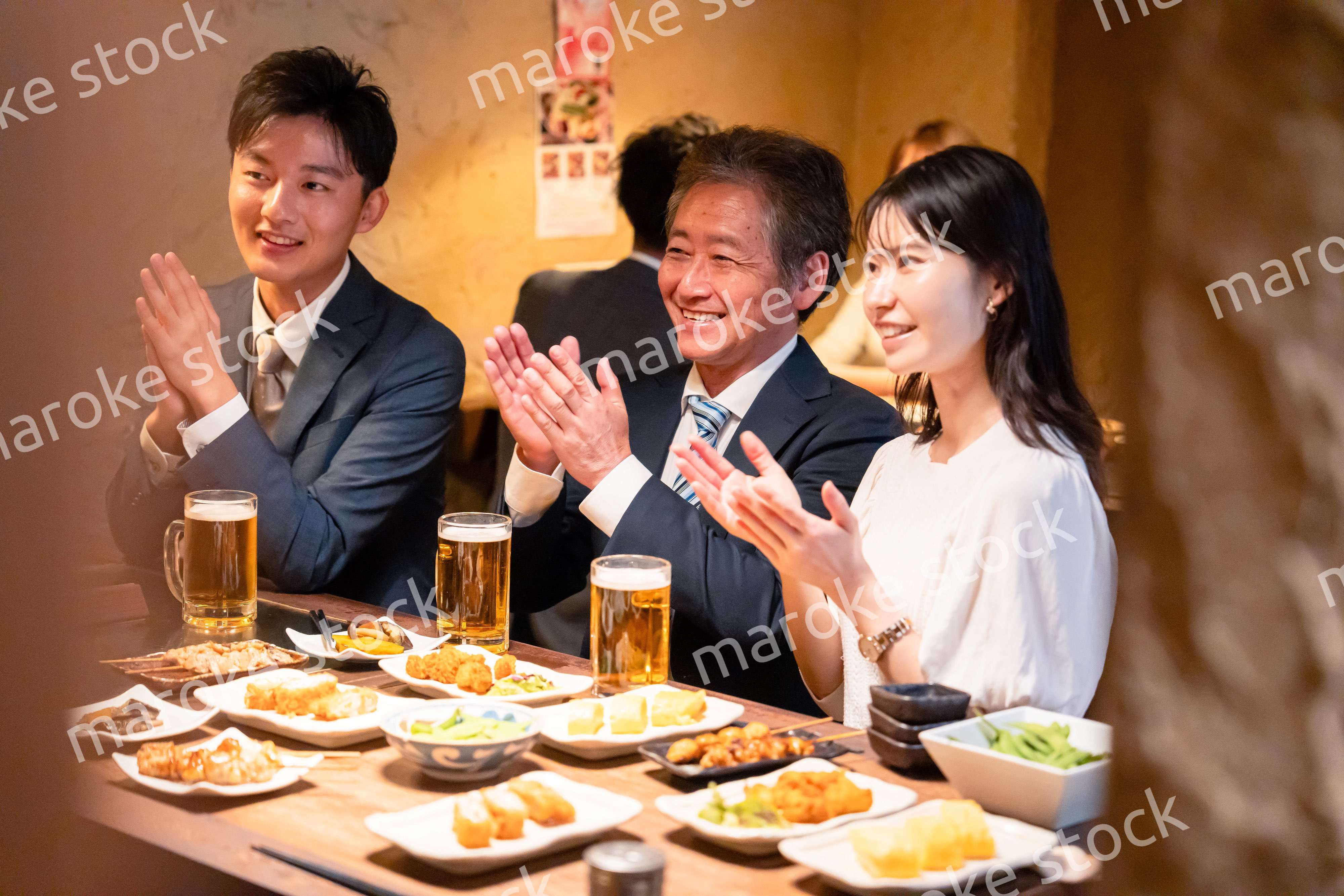 居酒屋でお祝いをするビジネスパーソン