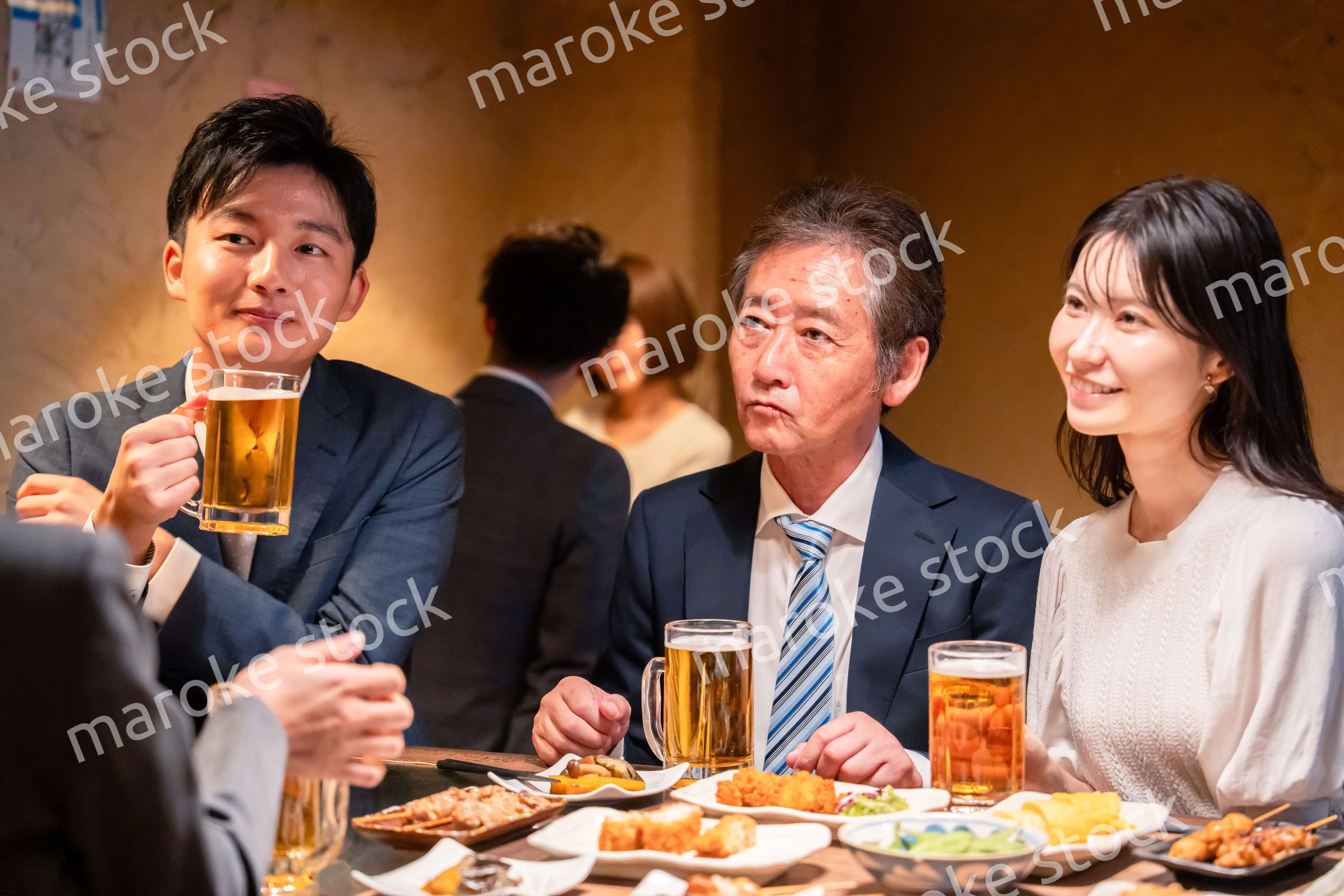 居酒屋で部署のお疲れ様会をするビジネスパーソン