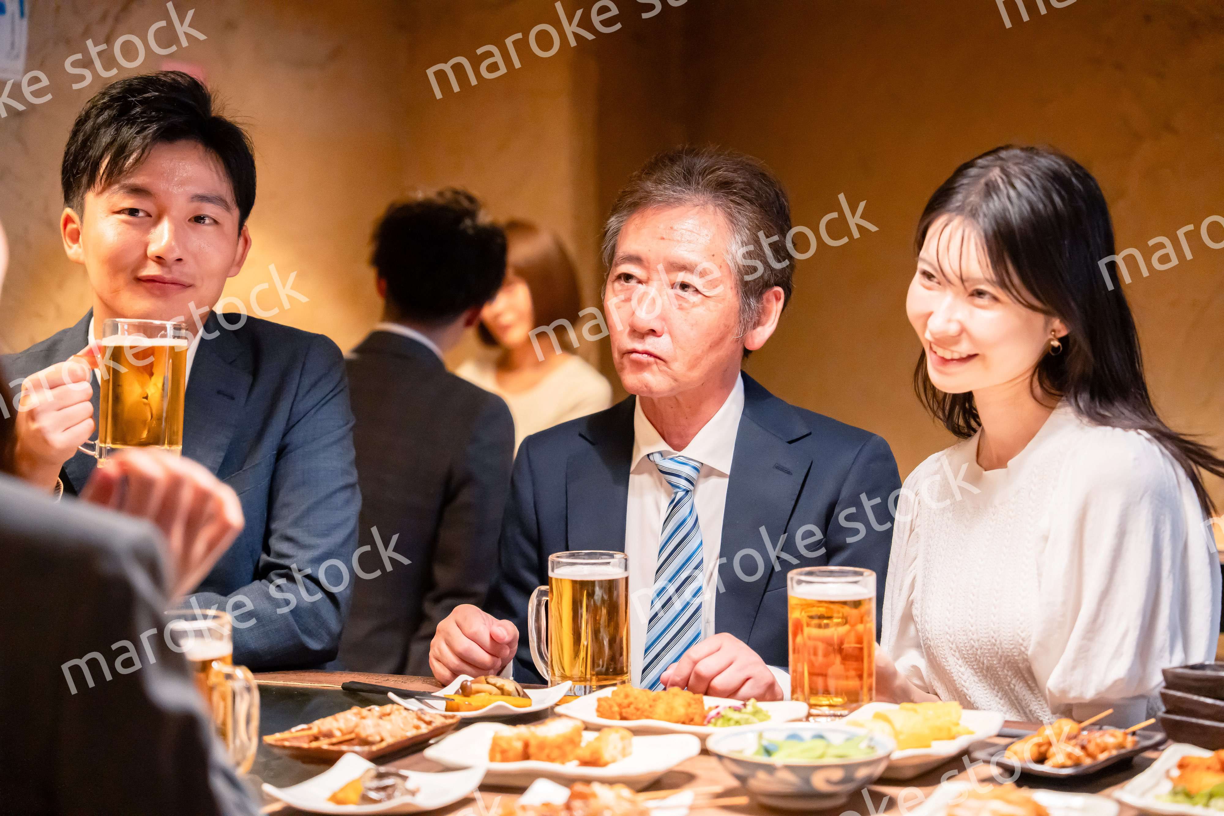 居酒屋で部署のお疲れ様会をするビジネスパーソン