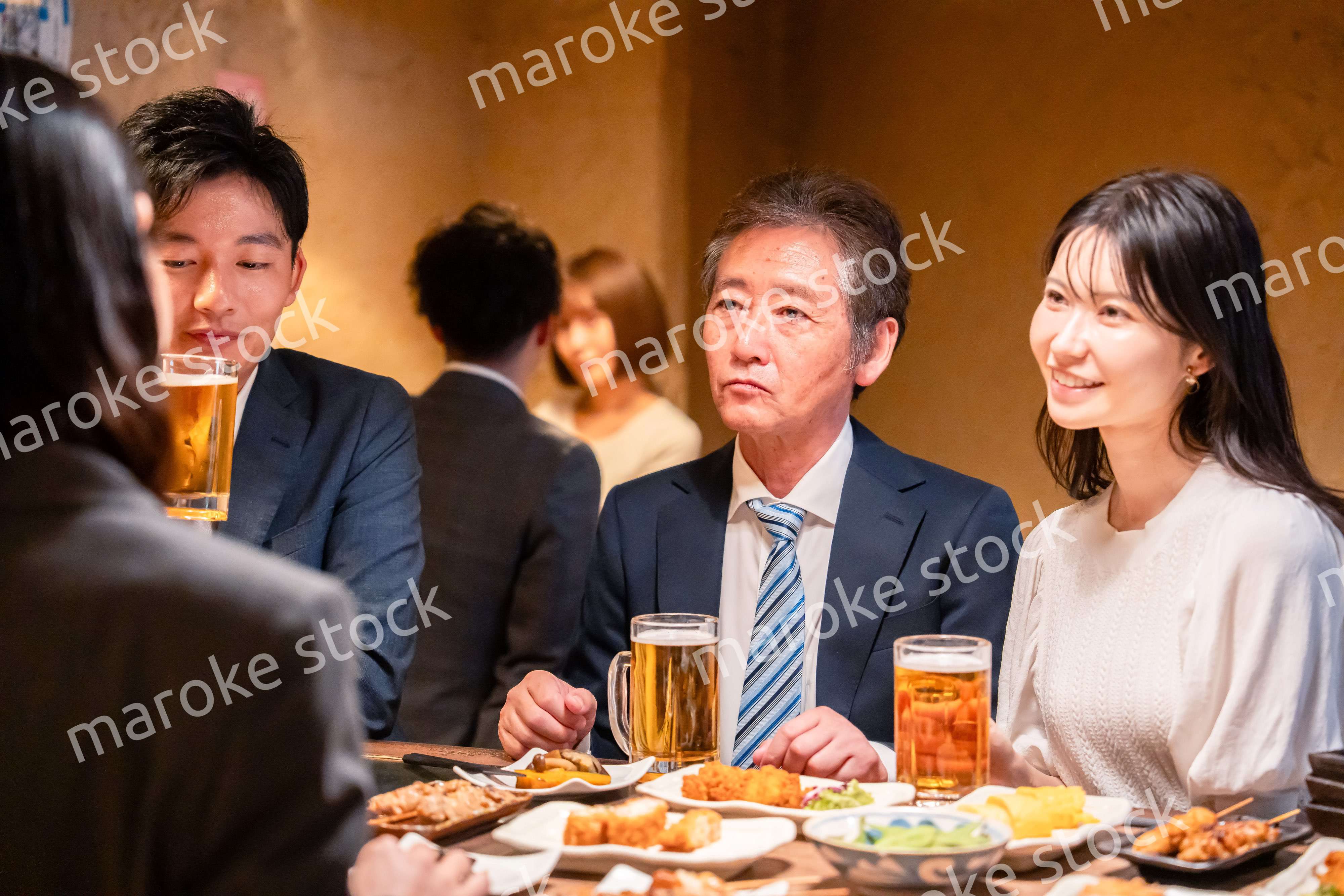 居酒屋で部署のお疲れ様会をするビジネスパーソン